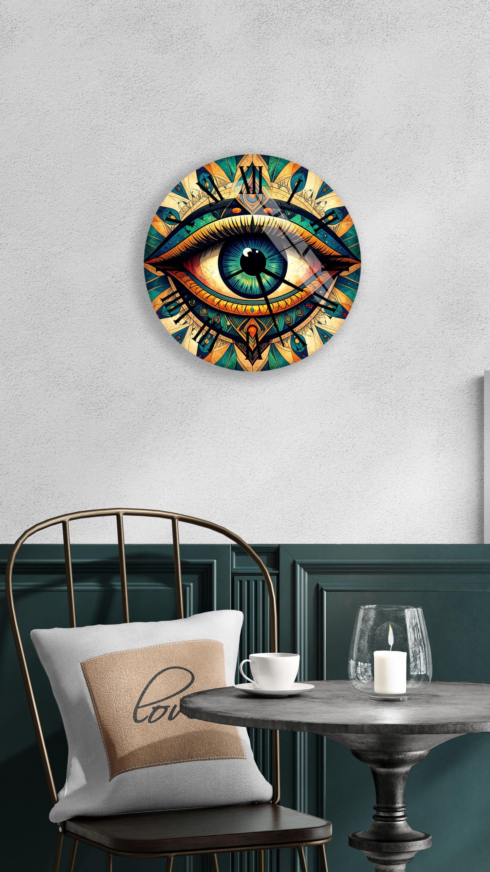 a wall clock with a large eye design, a white pillow with the word "love" on it, a small table with a candle and a glass, and a black metal chair.
