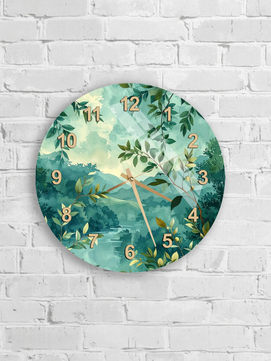 A round wall clock with a green and white nature-inspired design, featuring leaves, branches, and a landscape scene.