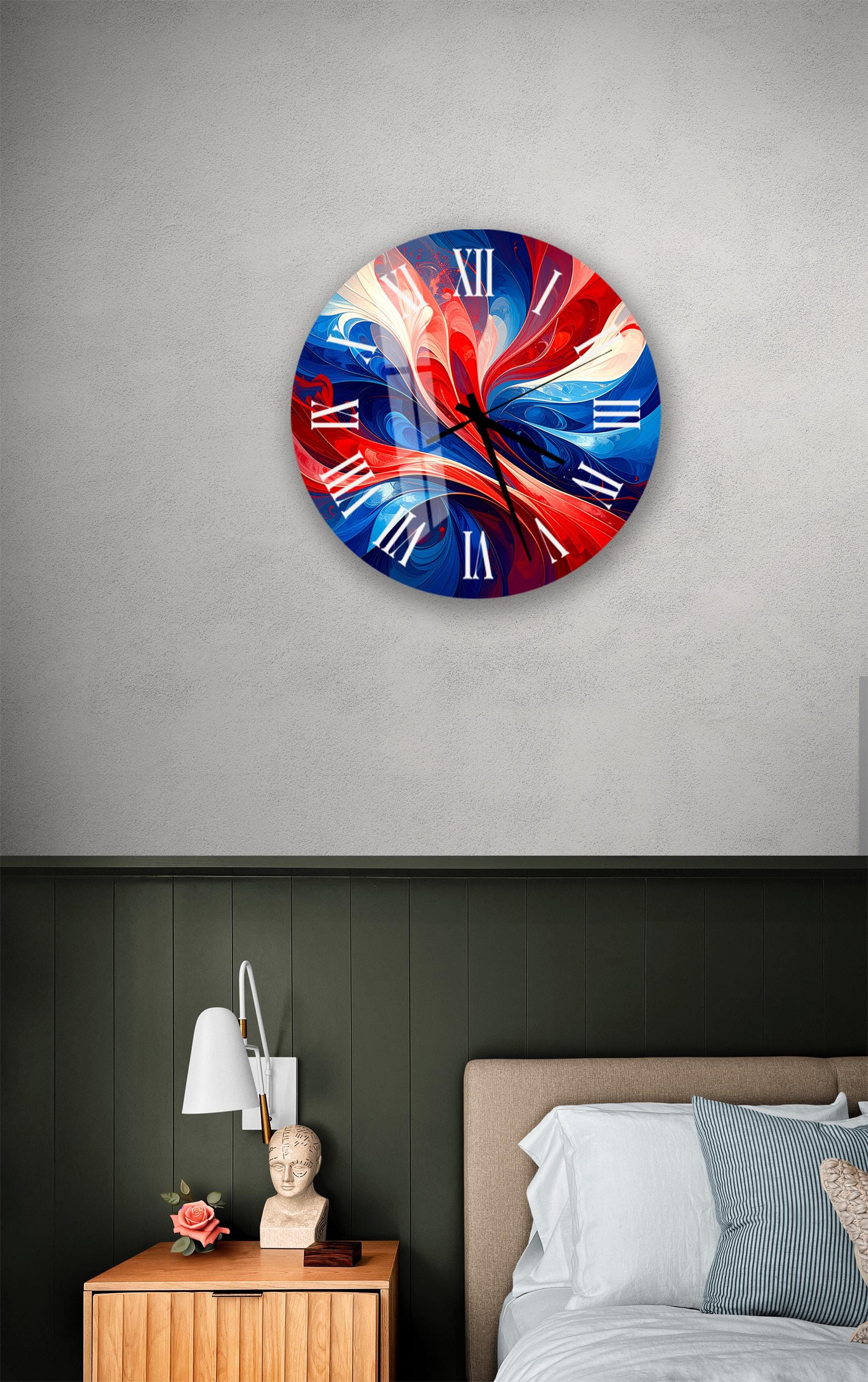 a bedroom setting with a large, colorful clock hanging on the wall above a bed. The clock has a vibrant design with red, blue, and white swirls. The room also includes a nightstand with a lamp and a small statue, as well as a striped pillow on the bed.