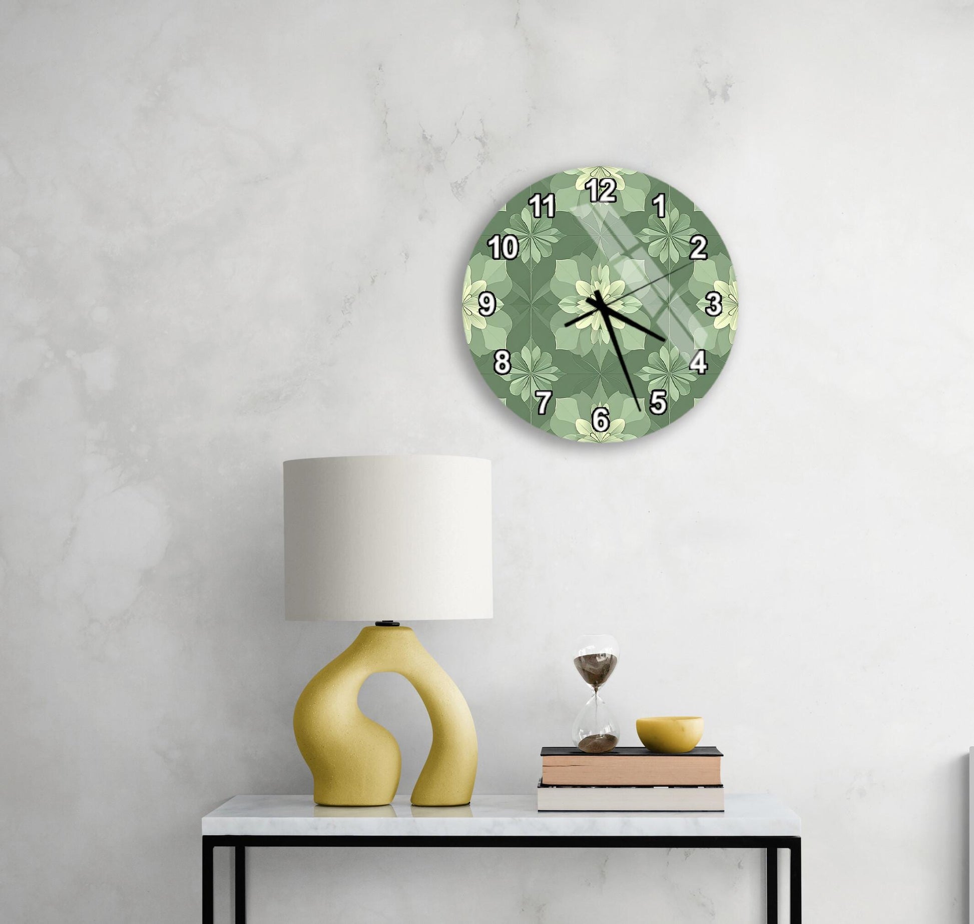 a modern living room with a white marble wall, a round green wall clock with a floral design, a yellow lamp with a unique curved base, a stack of books, and a glass of wine on a white table.