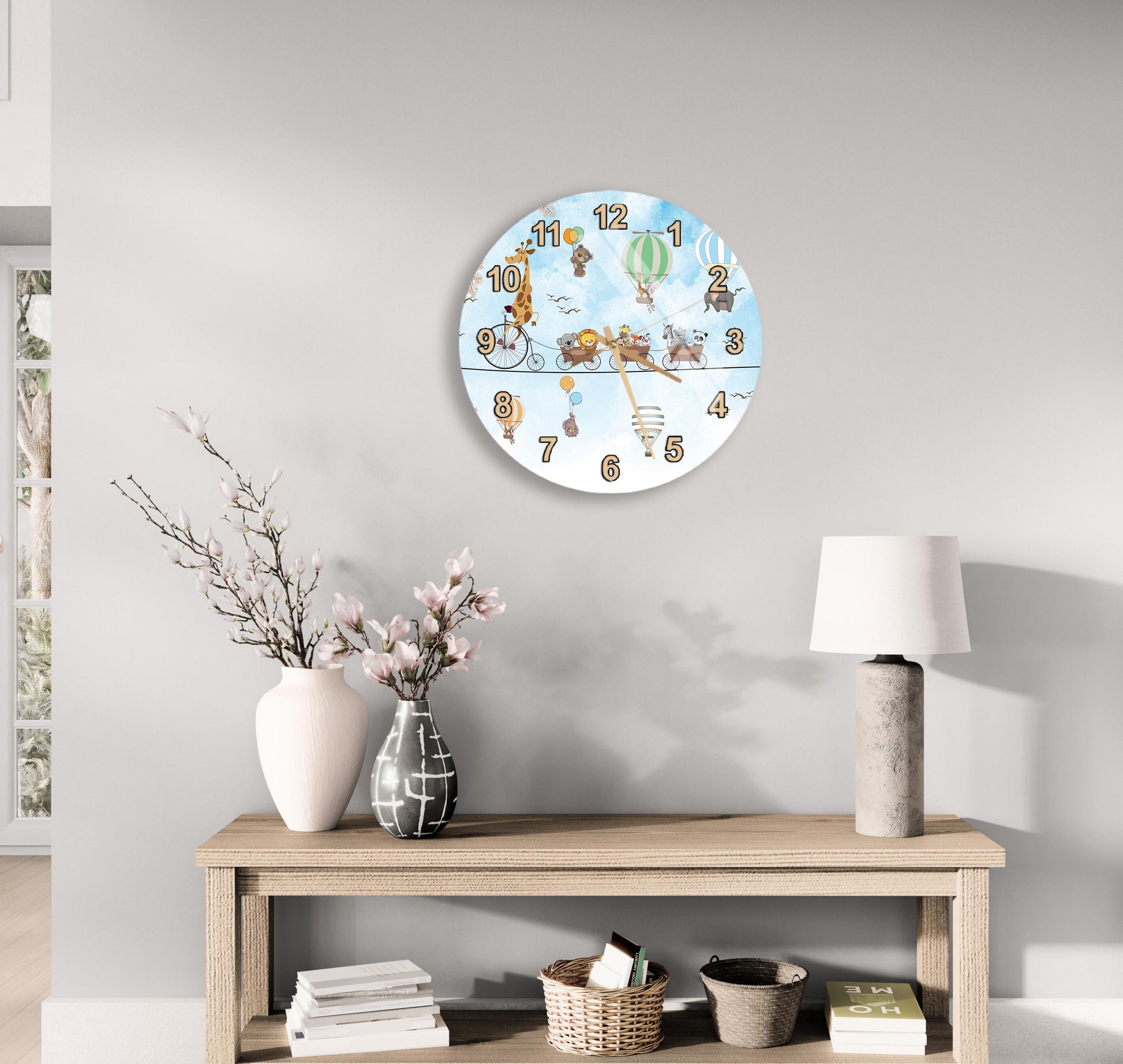 a wall clock with a whimsical design, a wooden table with a lamp, a vase with flowers, and some books on a shelf.