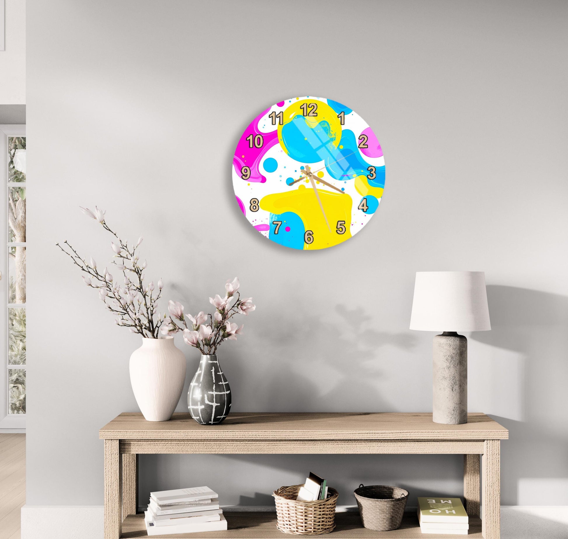 a modern and minimalist living room with a round clock on the wall, a wooden table with a lamp, a vase with flowers, and a stack of books.