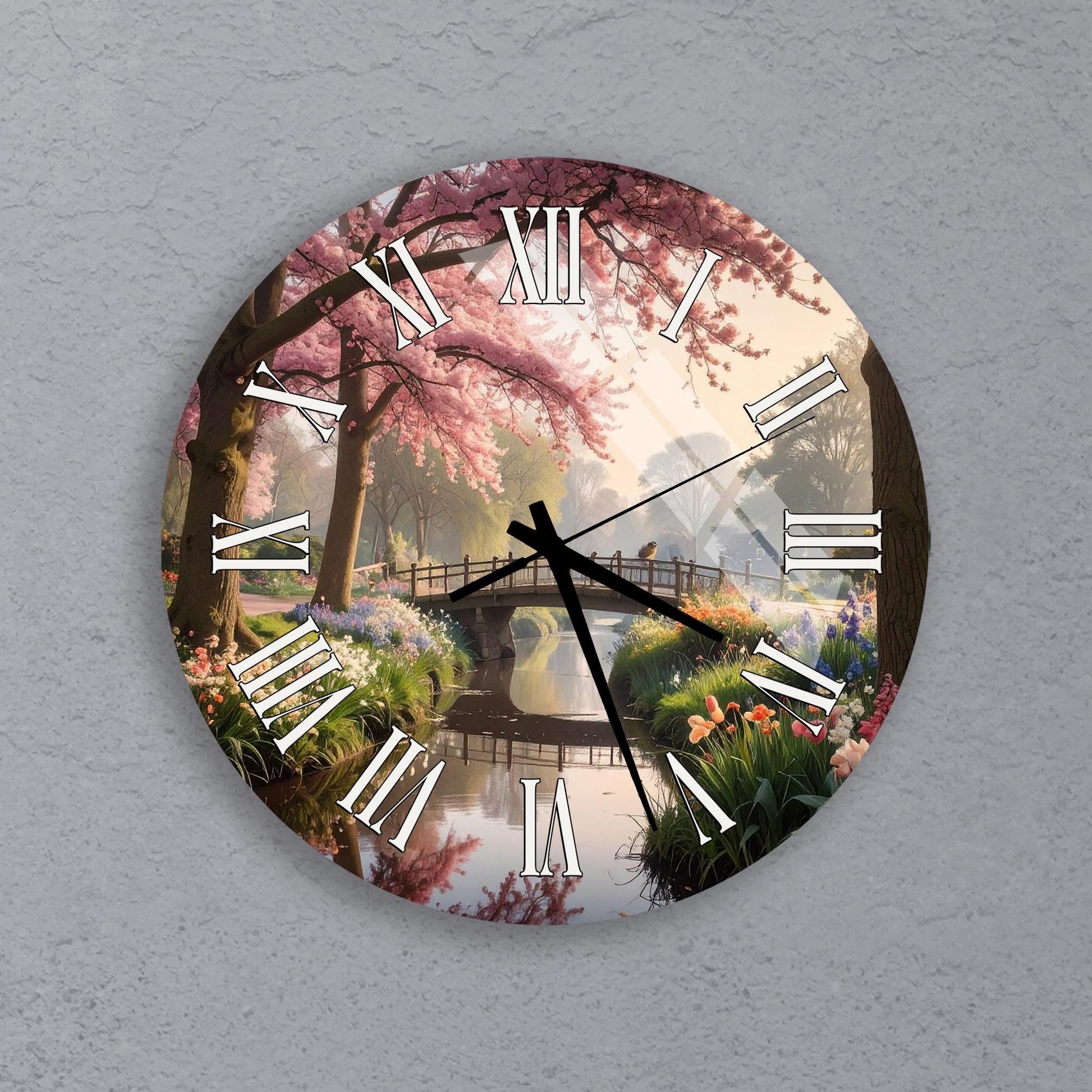 A wall clock with a floral design depicting a serene garden scene with a bridge, trees, and a pond.