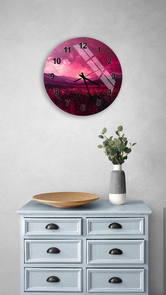 a wall clock with a pink and purple sunset design, mounted on a wall above a light blue dresser with six drawers. The dresser also has a vase with greenery and a wooden bowl on it.