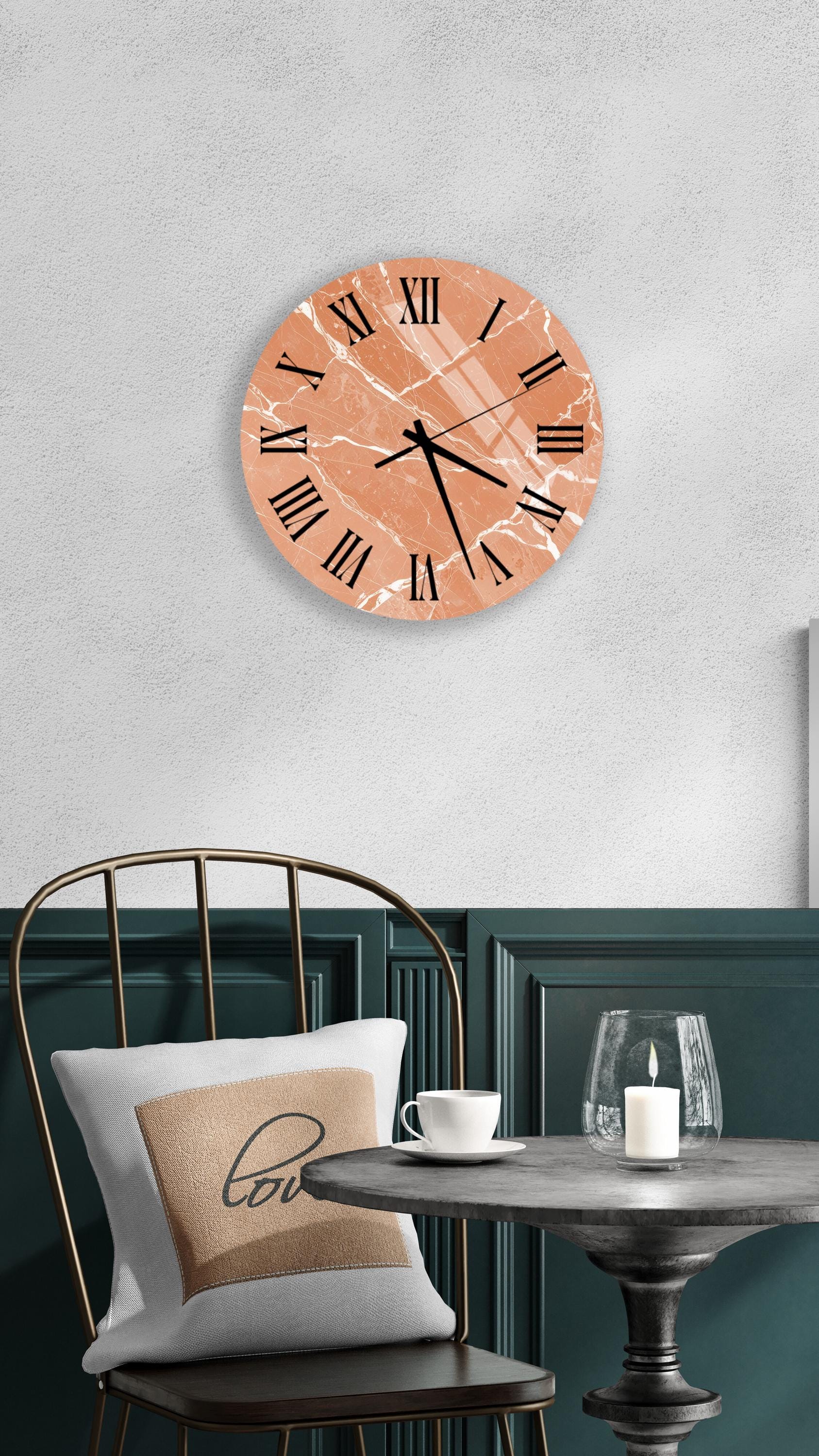 a modern interior design with a round wall clock, a black metal chair, a white table with a candle, and a beige pillow with the word "love" on it.
