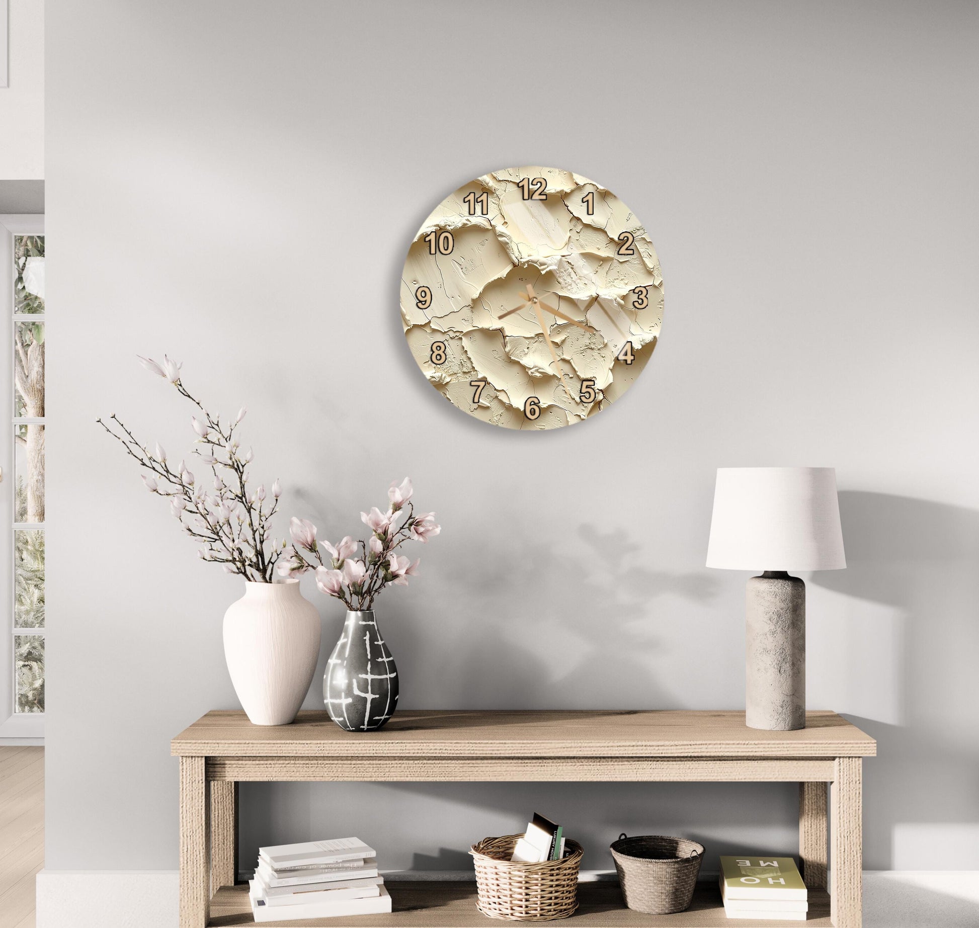 a modern living room with a wooden console table, a round clock with a distressed design, a vase with pink flowers, and a lamp on a side table.