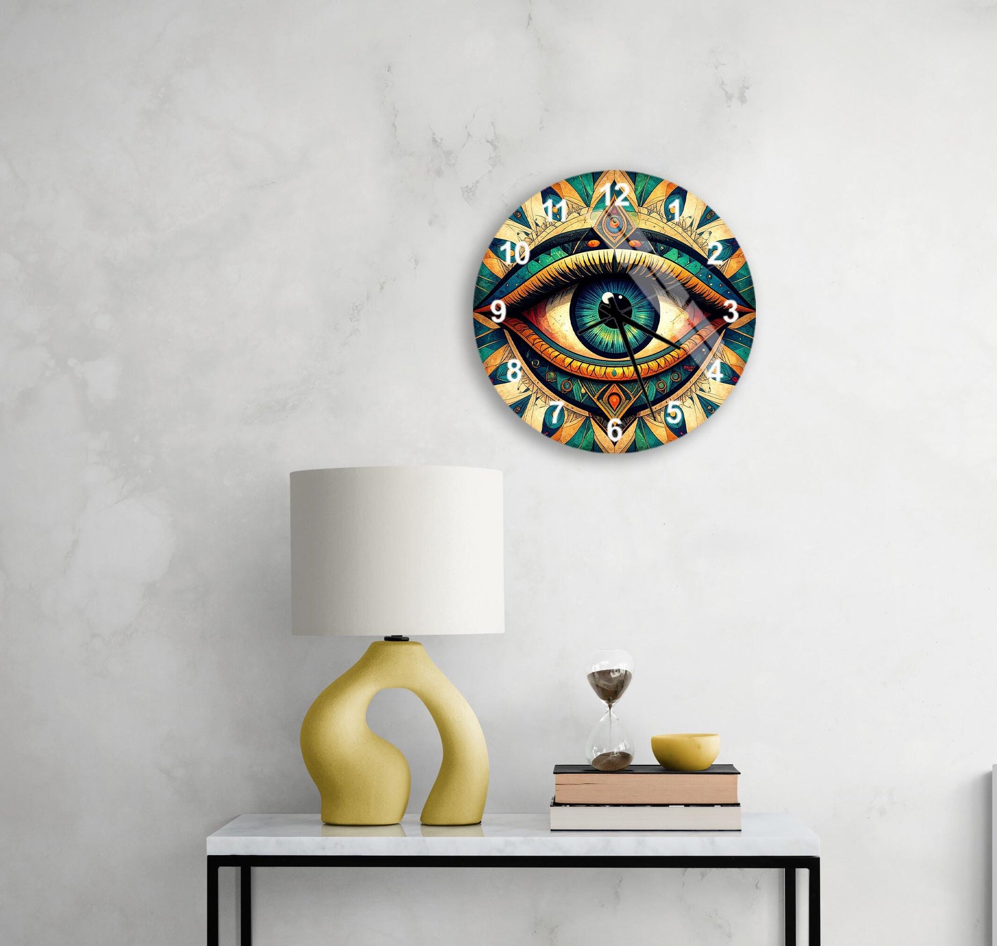 a wall clock with a colorful, eye-catching design, a yellow table lamp, a stack of books, and a glass of wine on a white table.