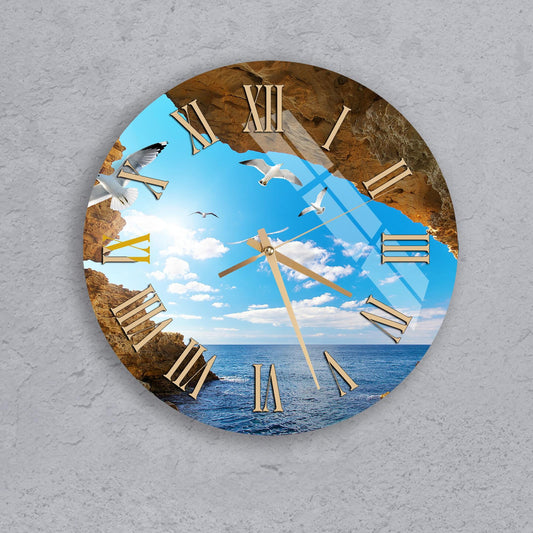 A wall clock with a beach scene displayed on its face, featuring seagulls flying over the ocean and a clear blue sky.