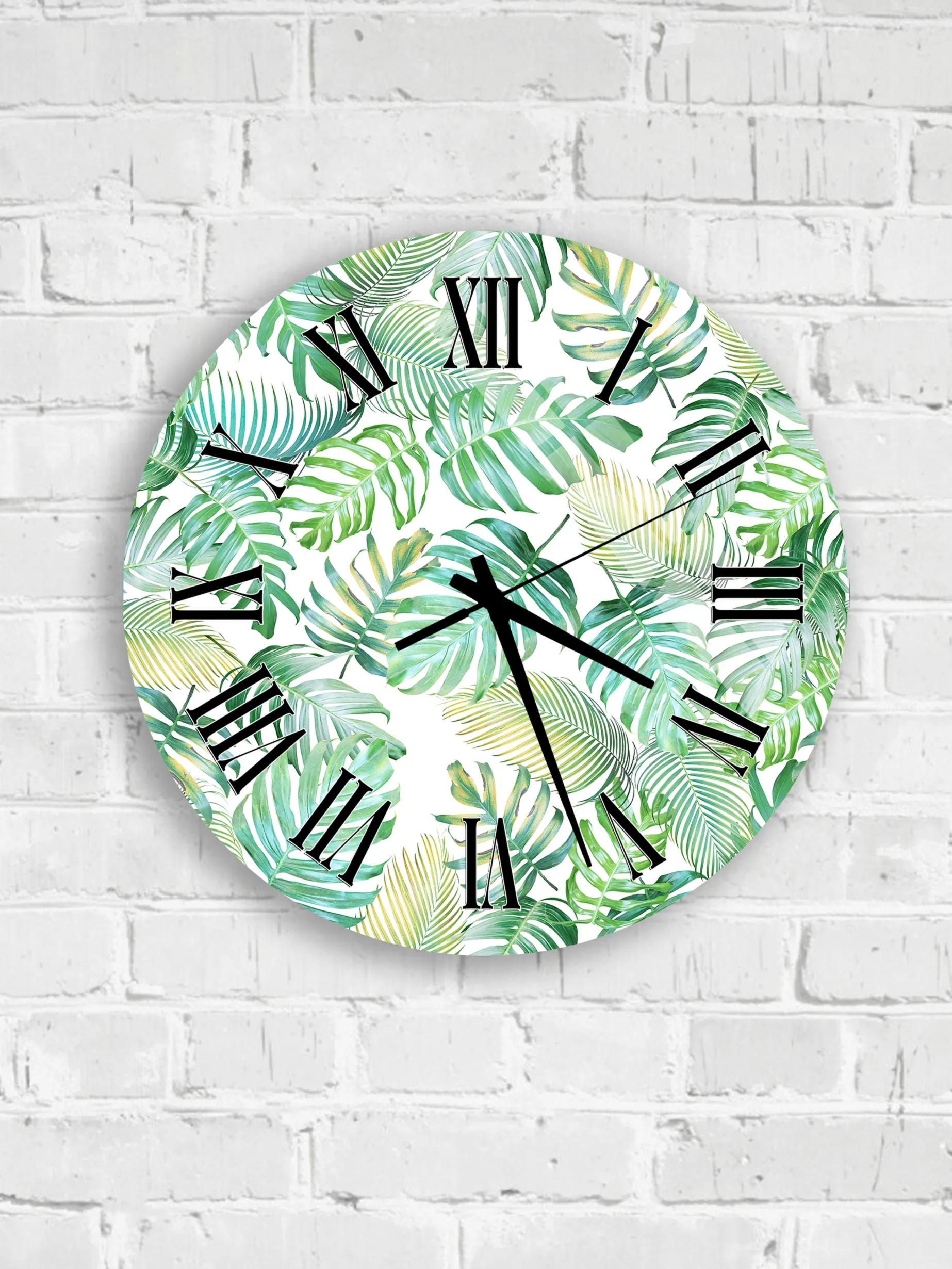 a collection of six round wall clocks with a tropical leaf pattern, arranged on a white brick wall.
