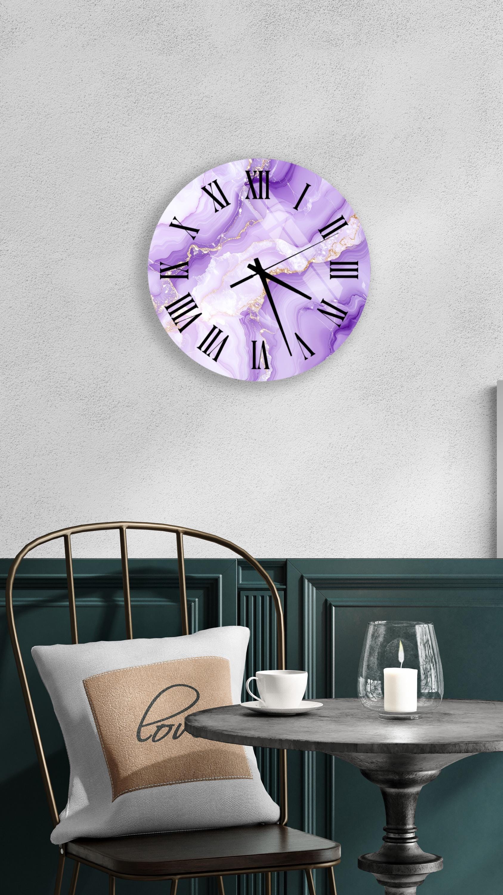 a wall clock with a purple marble design, mounted on a wall above a dining table with a white tablecloth. The table is set with a white cup and a candle, creating a cozy and inviting atmosphere.