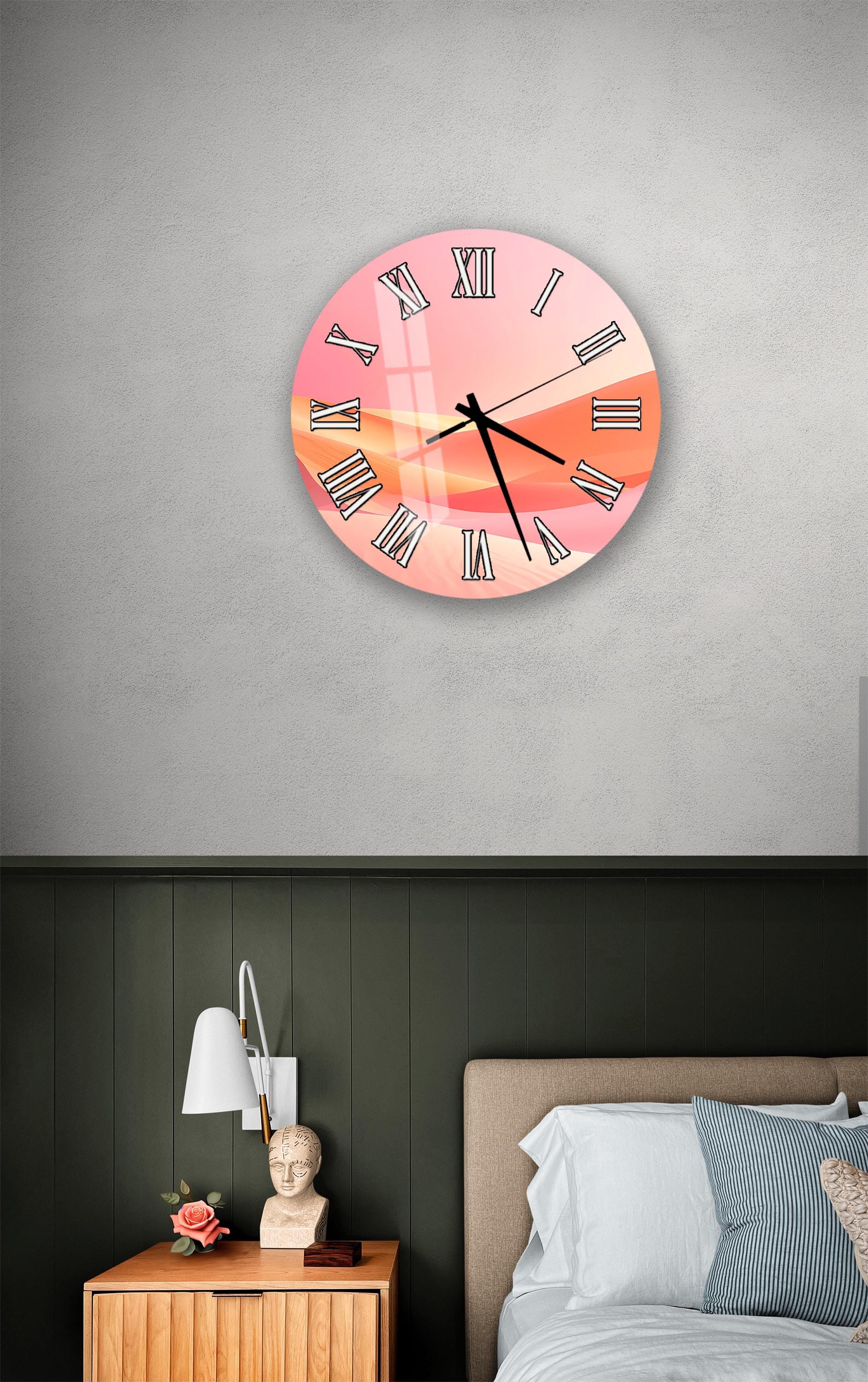 a bedroom setting with a wall clock displaying a sunset-like image, a wooden nightstand with a lamp, and a bed with white pillows.