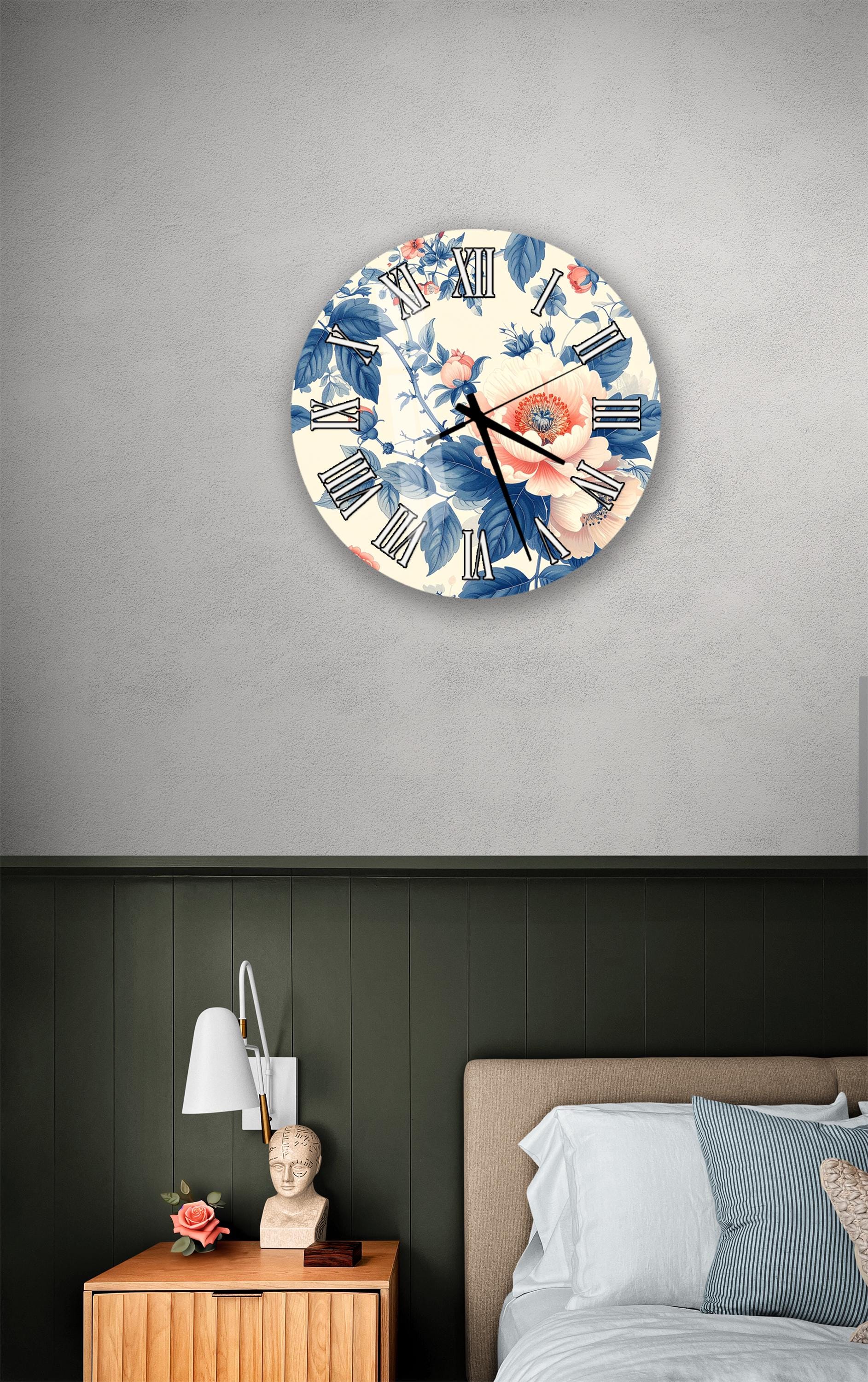 a bedroom setting with a wall clock displaying a floral design, a wooden nightstand with a lamp, and a bed with white sheets and blue pillows.