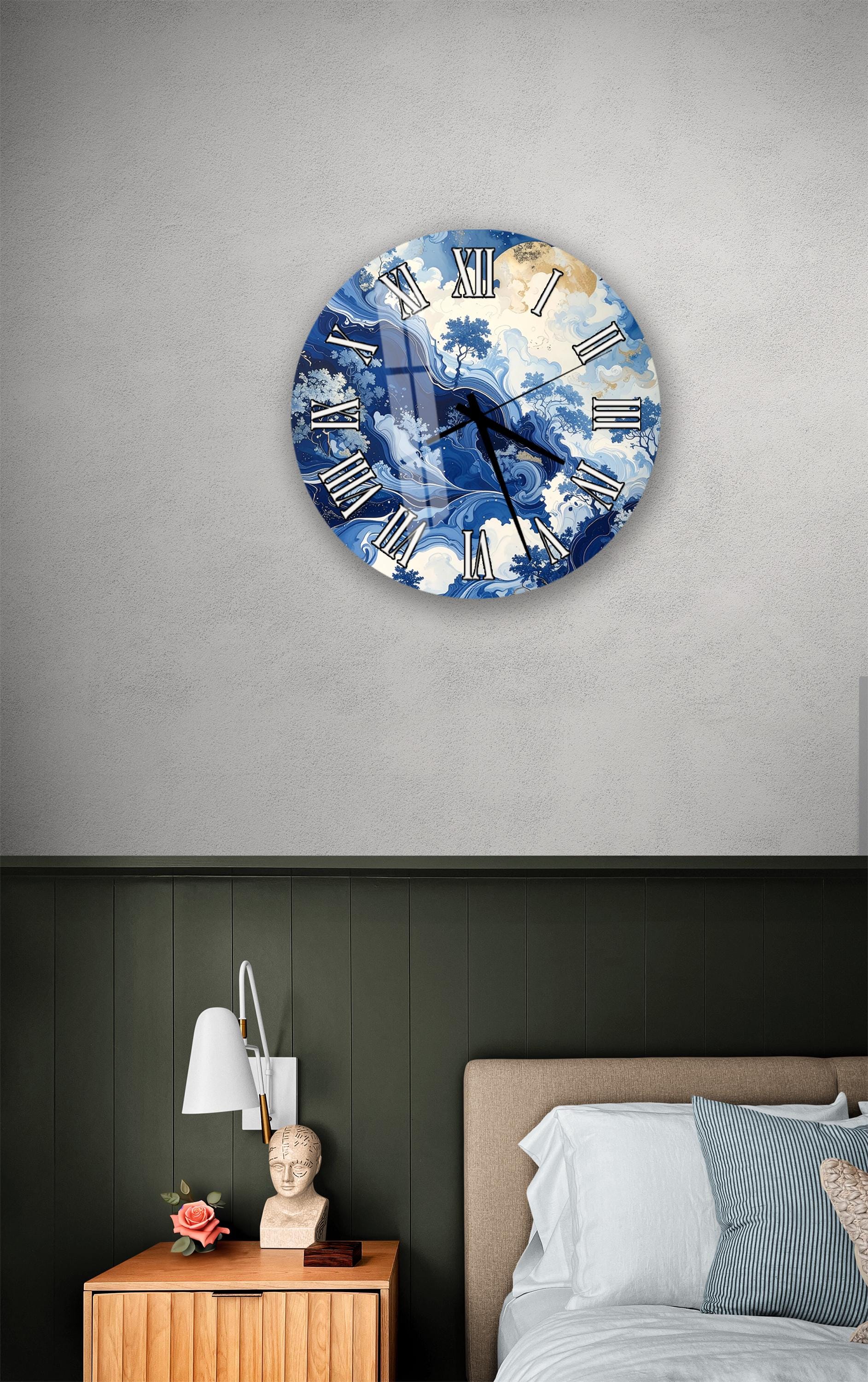 a bedroom setting with a large blue and white clock on the wall above a bed. The clock has a unique design with a cloud-like pattern on its face. The room also includes a nightstand with a lamp and a small statue or bust.