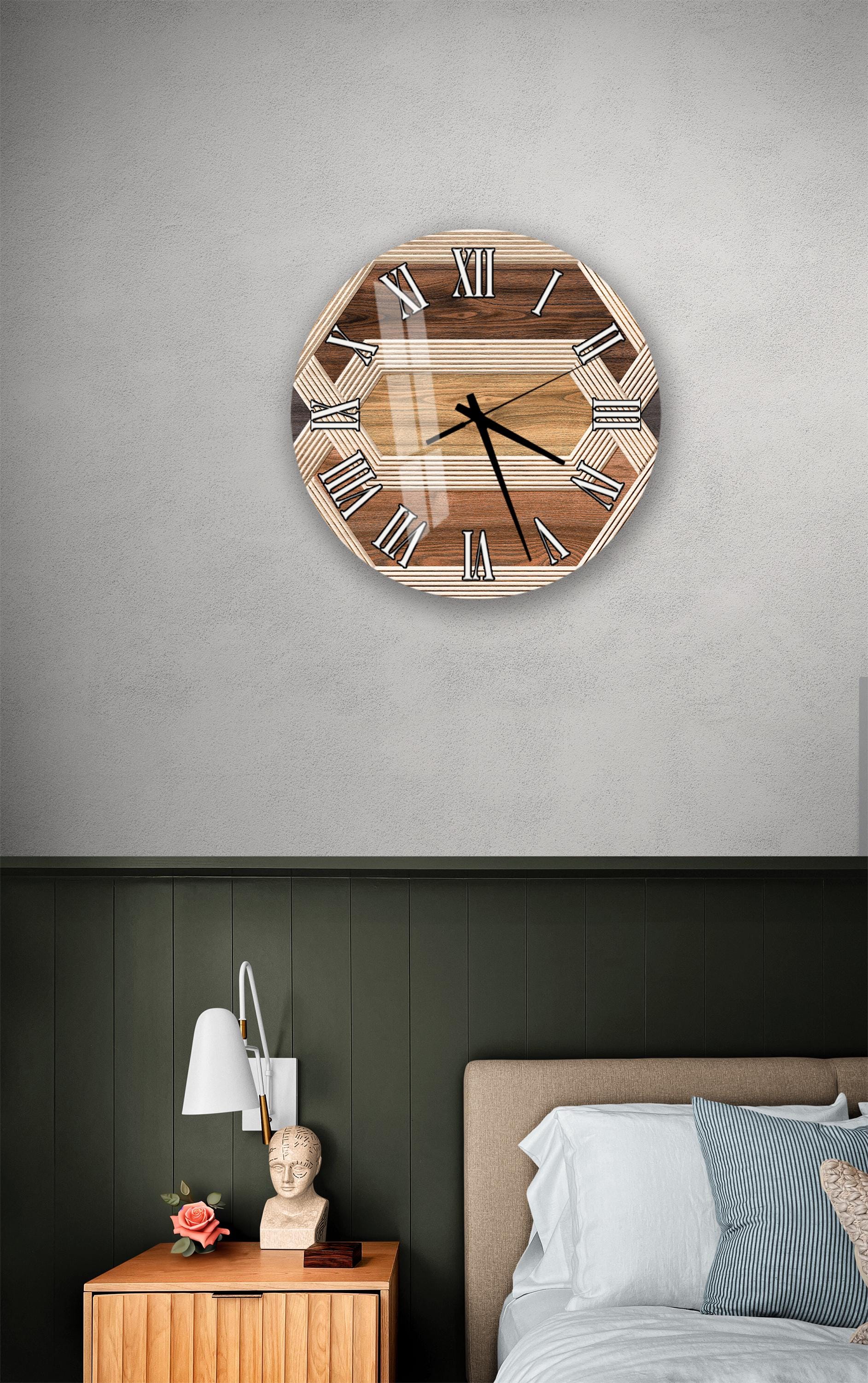 a bedroom setting with a wooden clock hanging on the wall above a bed. The clock has a wooden frame and Roman numerals on its face. The room has a green wall and a wooden nightstand with a lamp and a vase of flowers.