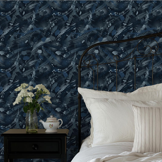 a bedroom with a black metal headboard, a white bedspread, and a wooden nightstand with a teapot and a vase of white flowers. The wall behind the bed has a blue and white abstract pattern.