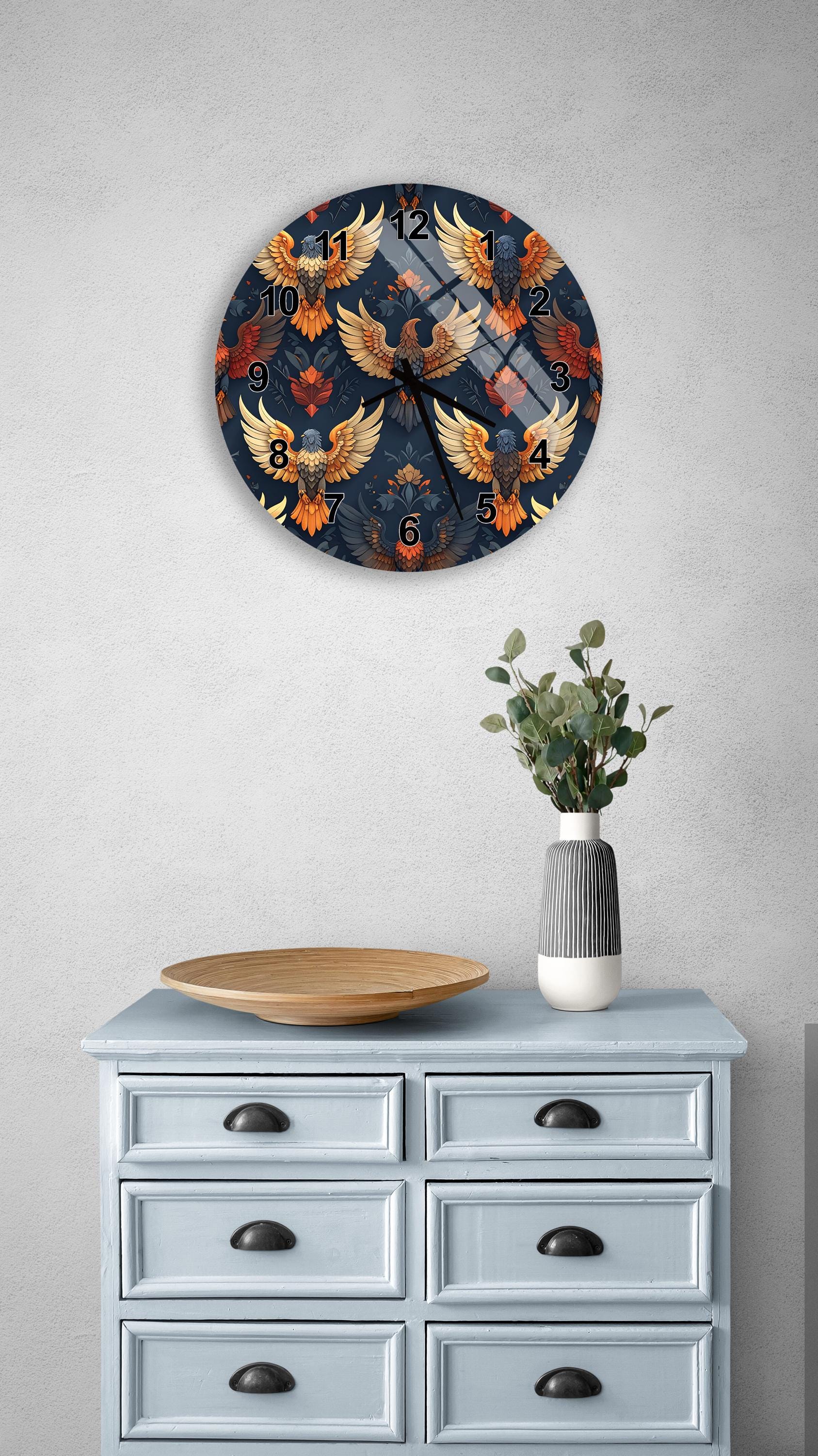 a wall clock with a vibrant, colorful design of birds and a vase with greenery on a light blue dresser.