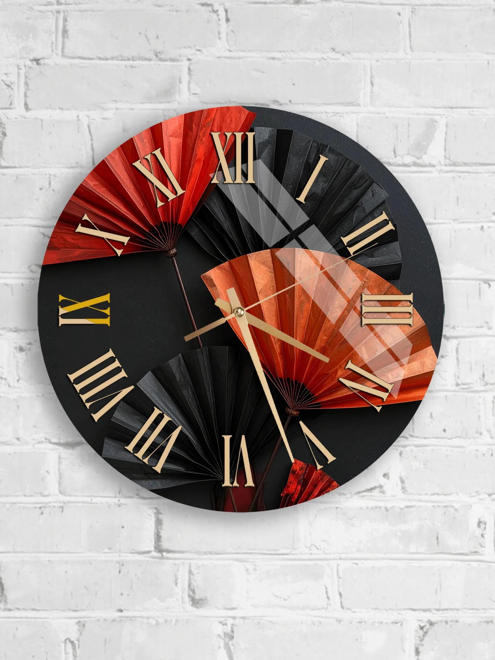 A wall clock with a black and red design, featuring a fan-like pattern and Roman numerals.