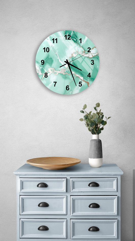 a wall clock with a marble-like design, mounted on a wall above a light blue dresser with six drawers. The dresser also has a vase with greenery on it, and a wooden bowl on top.