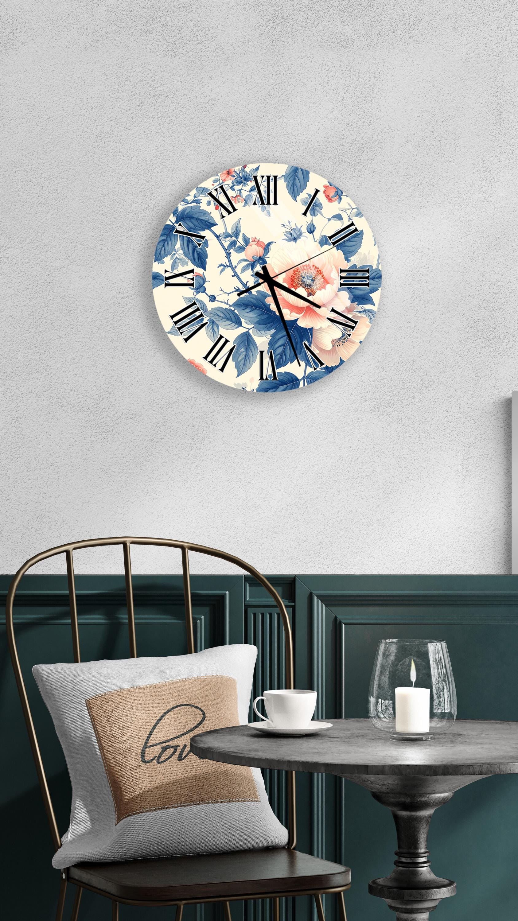 a wall clock with a floral design, a table with a white cup and a candle, and a chair with a pillow.