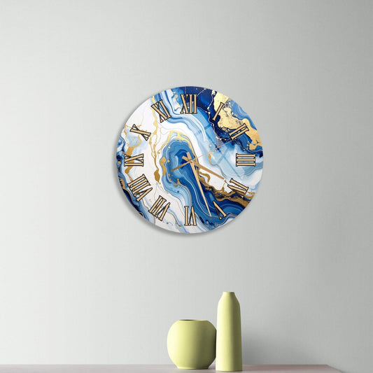 a modern clock with a marble-like design, mounted on a wall above a wooden dresser. The dresser has three drawers and contains a yellow vase and a small green pot.