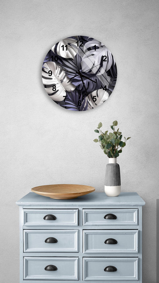 a wall clock with a black and white leaf pattern, a wooden bowl, a vase with greenery, and a light blue dresser with six drawers.