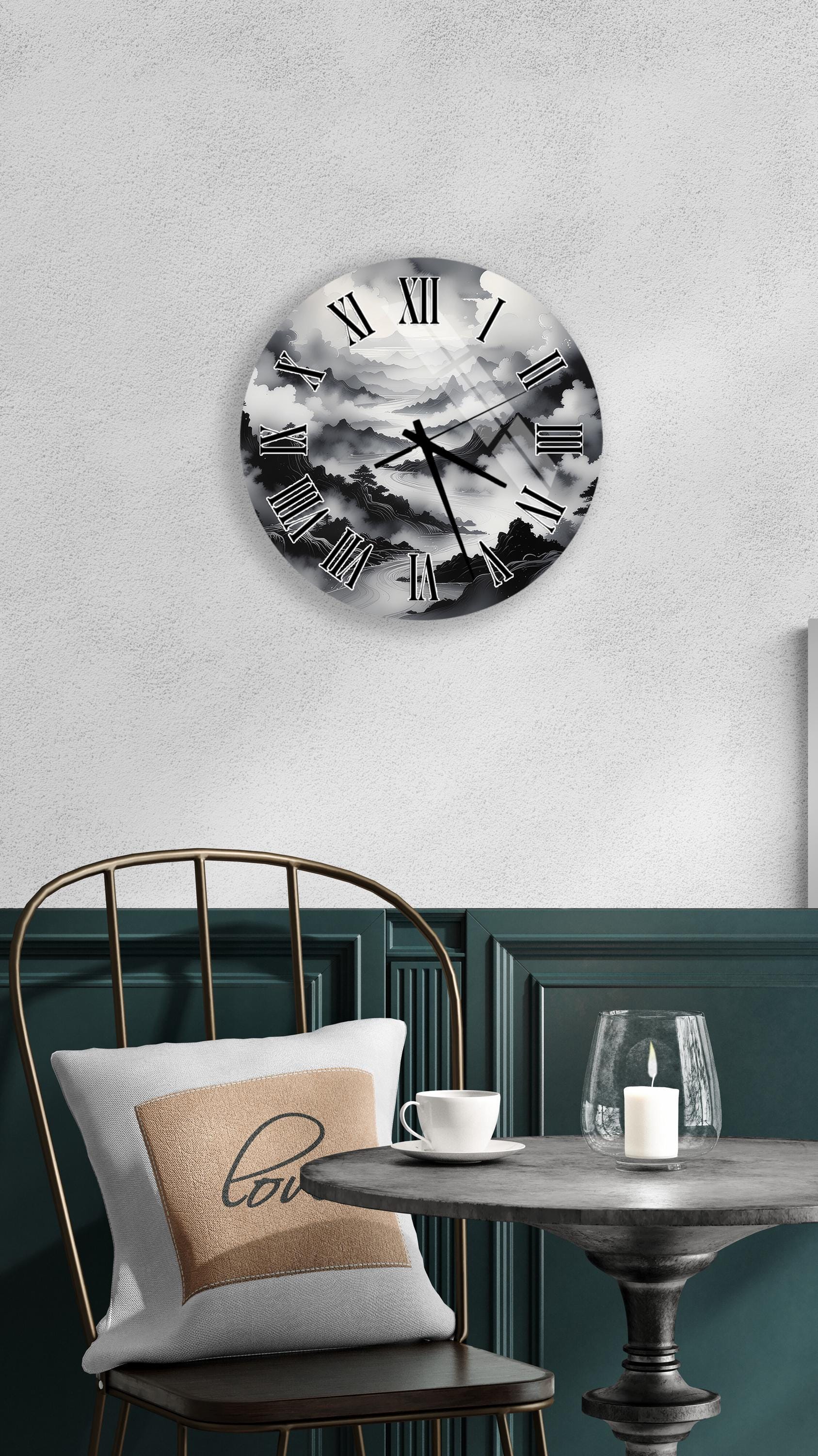 a wall clock with a black and white design, mounted on a wall above a table with a white tablecloth. The table has a candle and a cup on it, creating a cozy and inviting atmosphere.