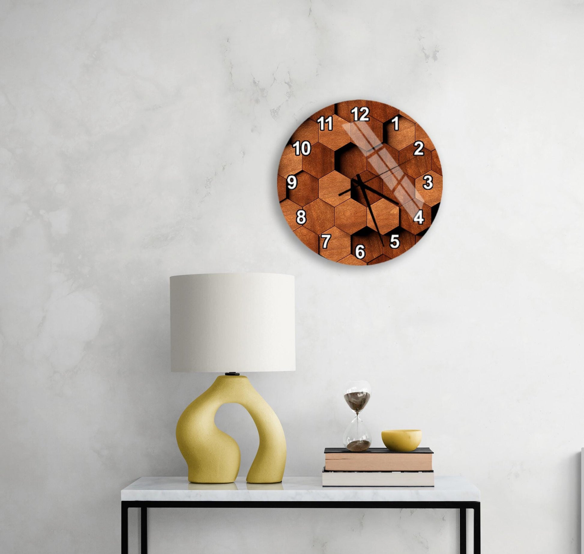 a modern interior design with a white wall, a round wooden clock with a hexagonal pattern, a yellow lamp with a unique curved base, and a small table with a book and a glass of wine.