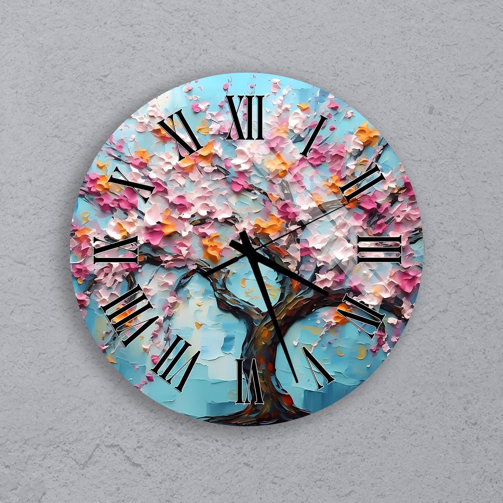 A round wall clock with a blue background and a tree with pink and orange flowers.