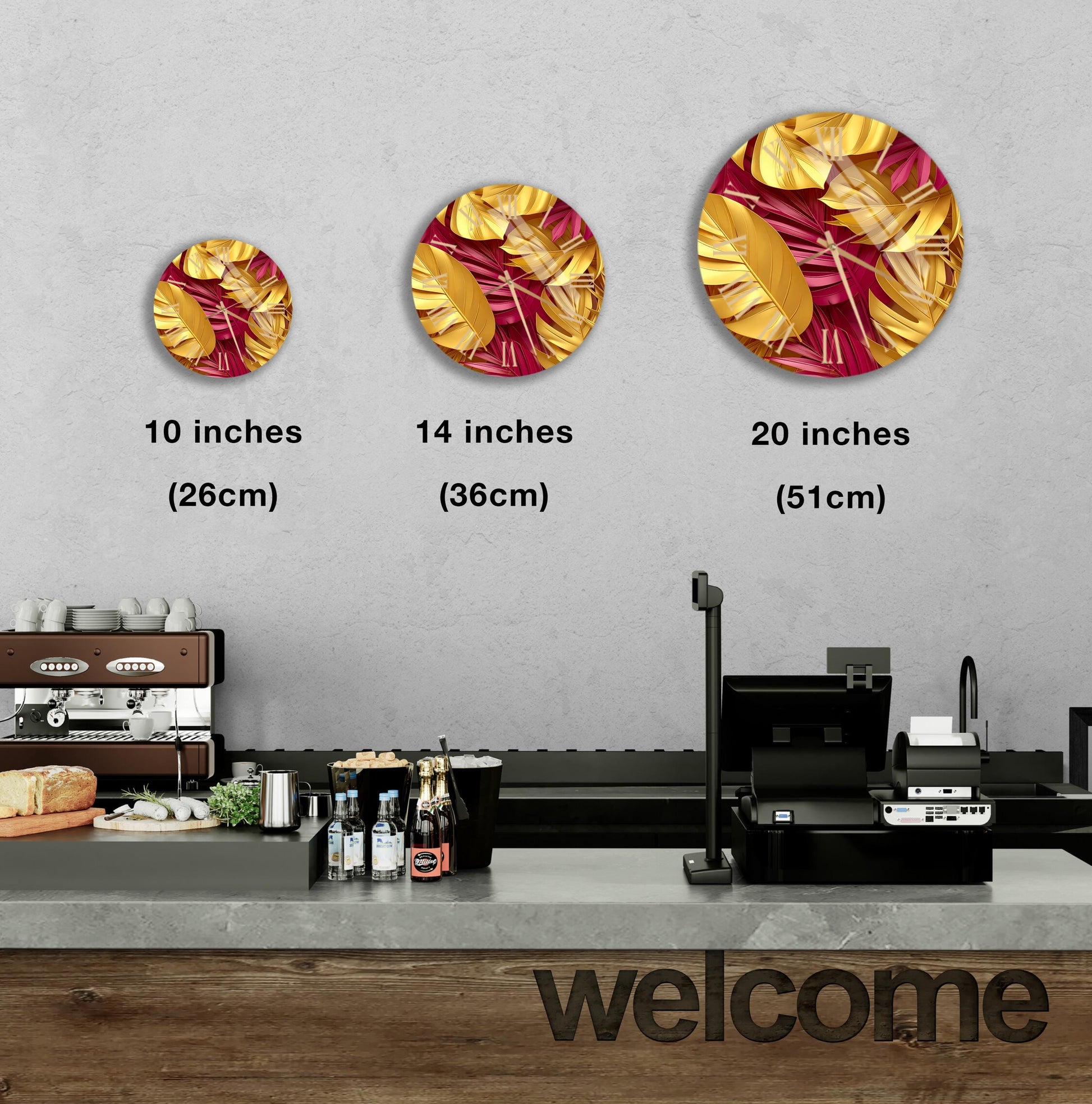 a counter in a restaurant with a welcome sign, and there are three different sizes of circular wall art depicting tropical leaves in gold and red colors.