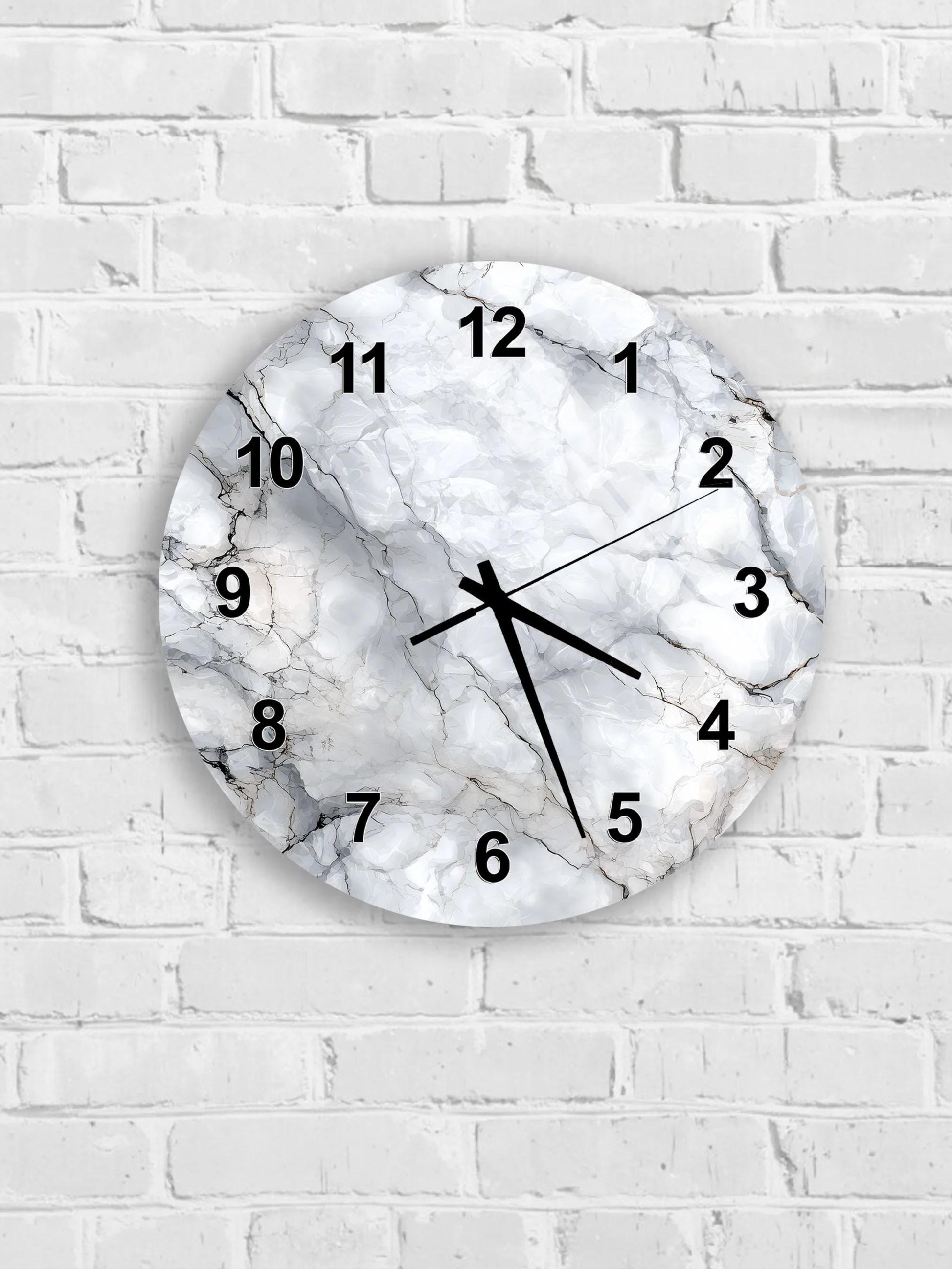 A round wall clock with a marble-like design, mounted on a white brick wall.