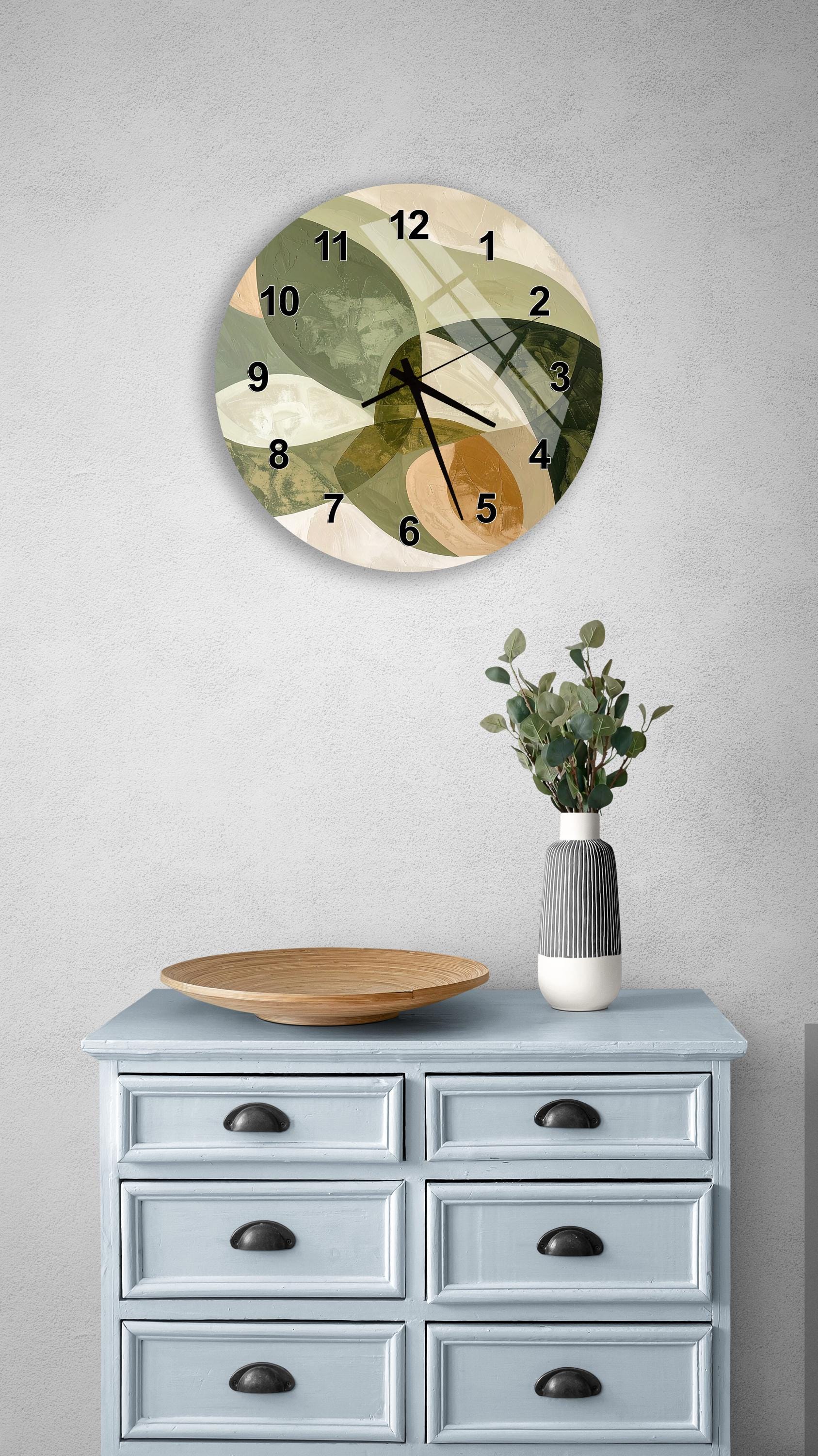 a wall clock with a unique abstract design, a wooden tray, a vase with greenery, and a light blue dresser with six drawers.
