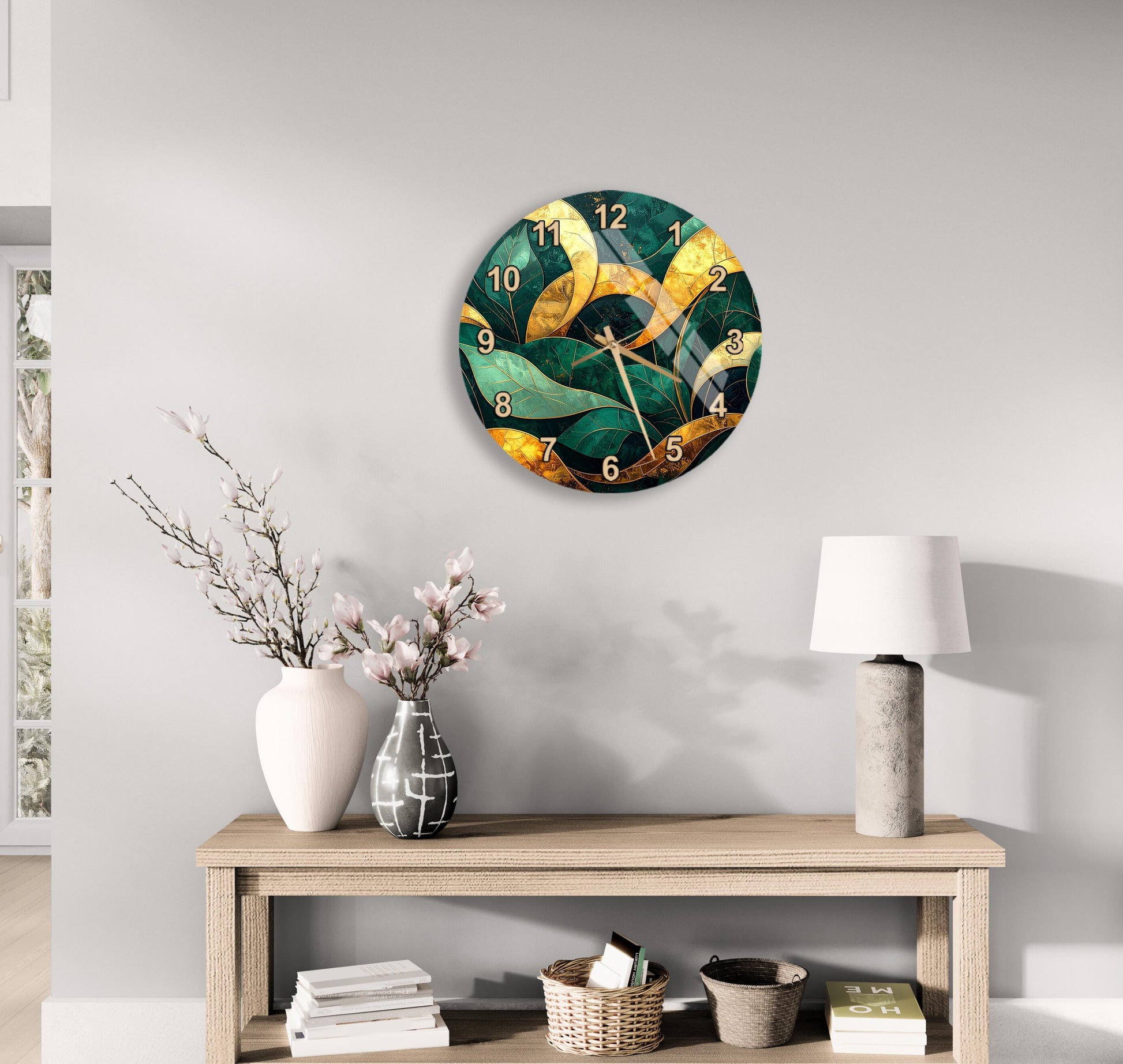 a modern living room with a large wall clock displaying a green and gold design, a wooden table with a lamp, a vase with flowers, and a stack of books.