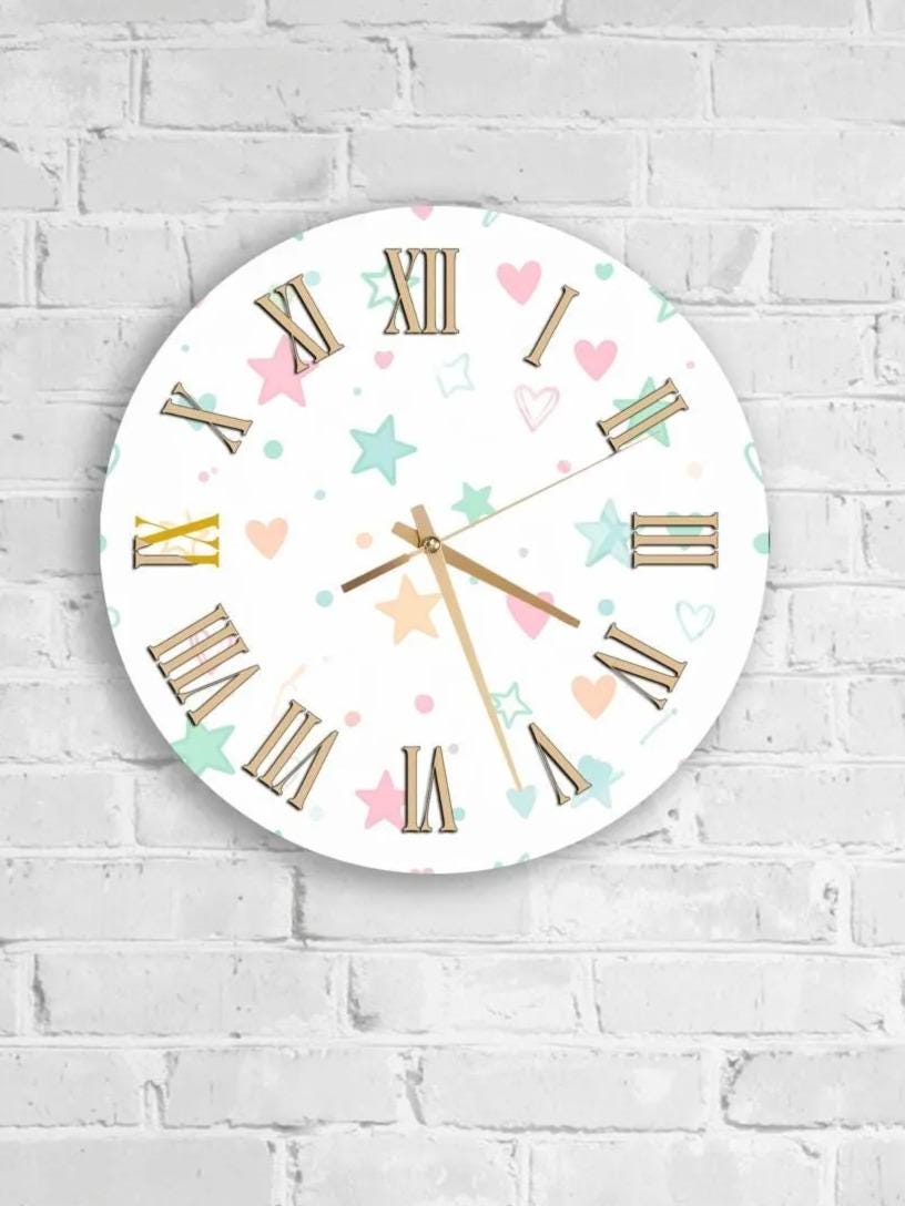 A round wall clock with Roman numerals and colorful star and heart designs on a white brick wall.