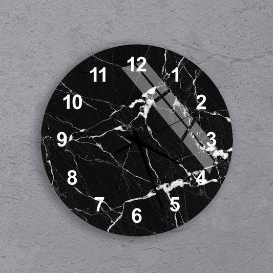 A black and white clock with a marble-like texture and white numbers on a gray background.