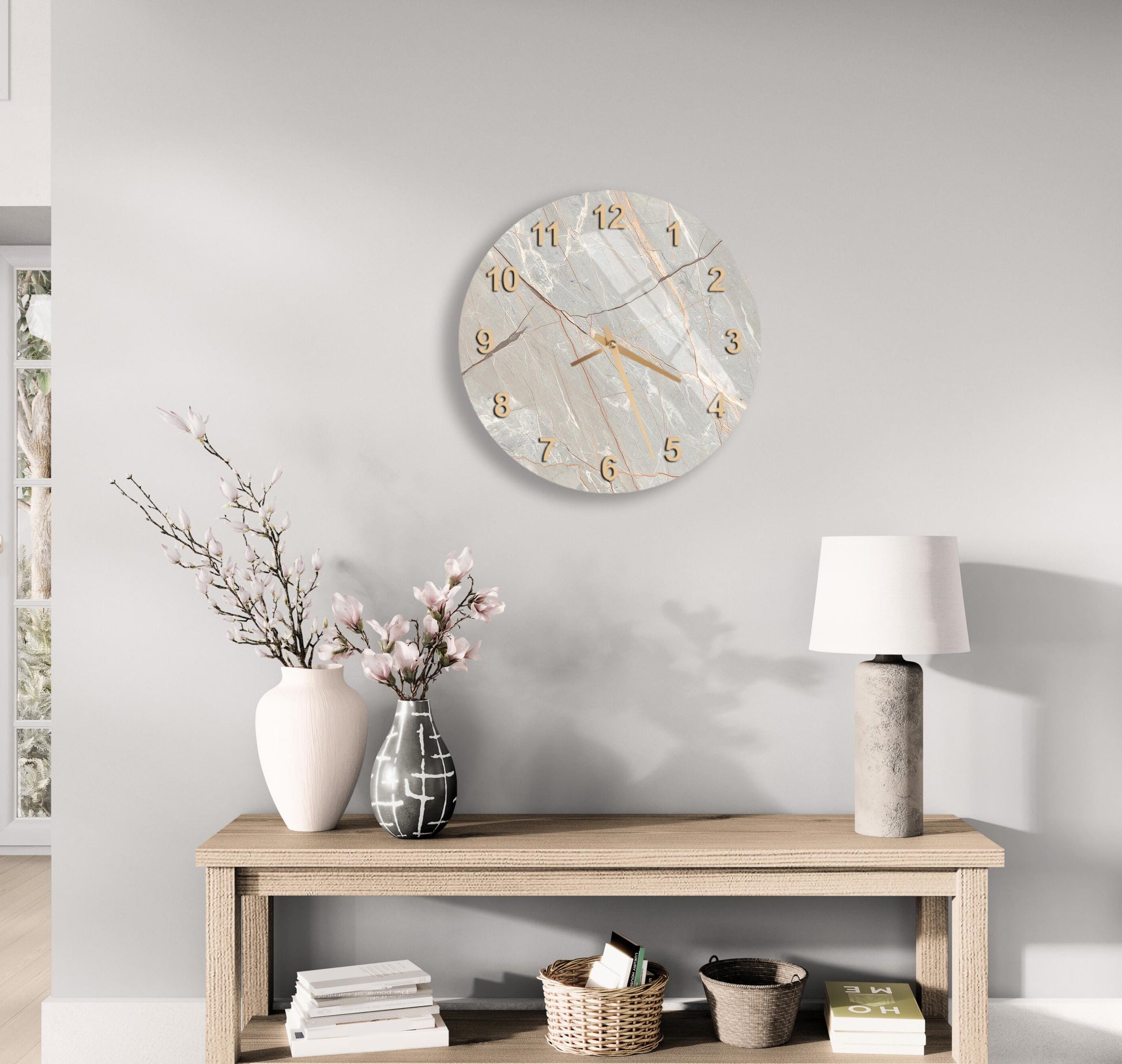 a modern and minimalist living room with a wooden console table, a round wall clock, and various decorative elements such as a vase with flowers, a lamp, and a stack of books.