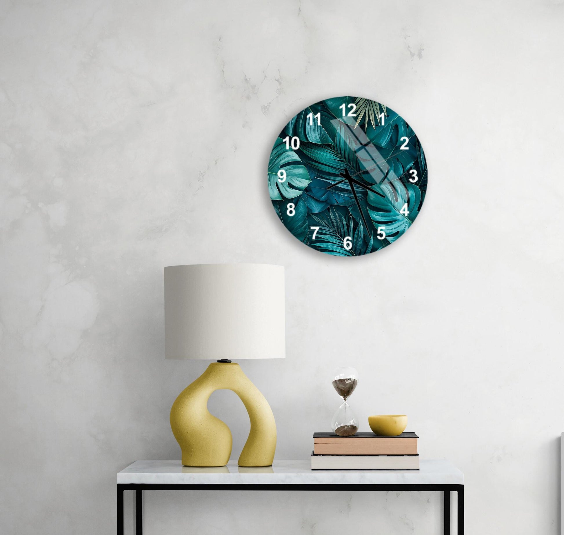 a modern living room with a round wall clock displaying a tropical plant design, a yellow lamp with a unique curved base, a stack of books, and a glass of wine on a white table.