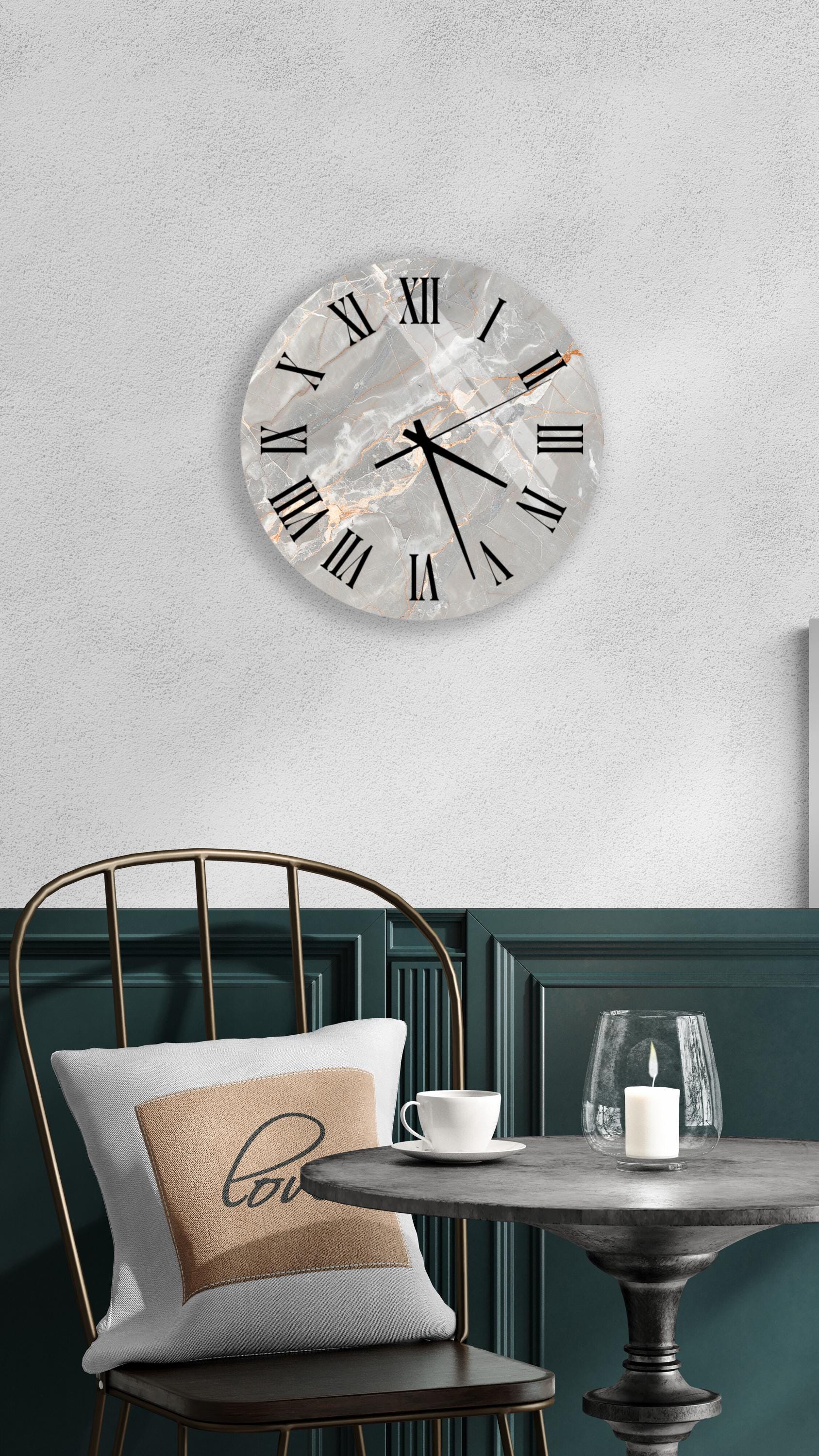 a modern interior design with a round wall clock, a white table with a candle, and a black chair with a pillow.