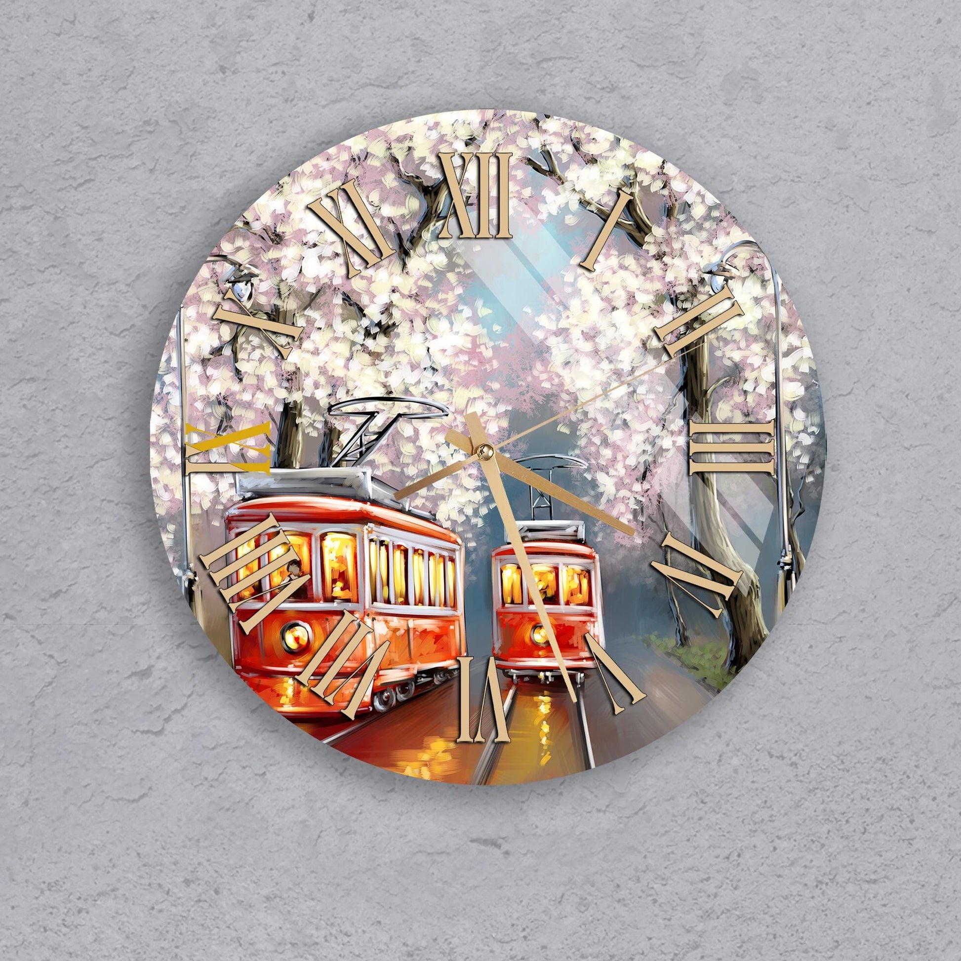 A clock with a design featuring two red trolley cars and a background of blooming cherry blossom trees.