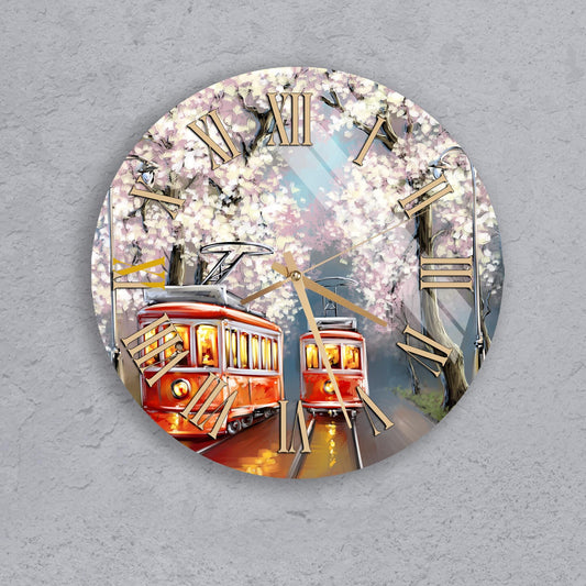 A clock with a design featuring two red trolley cars and a background of blooming cherry blossom trees.