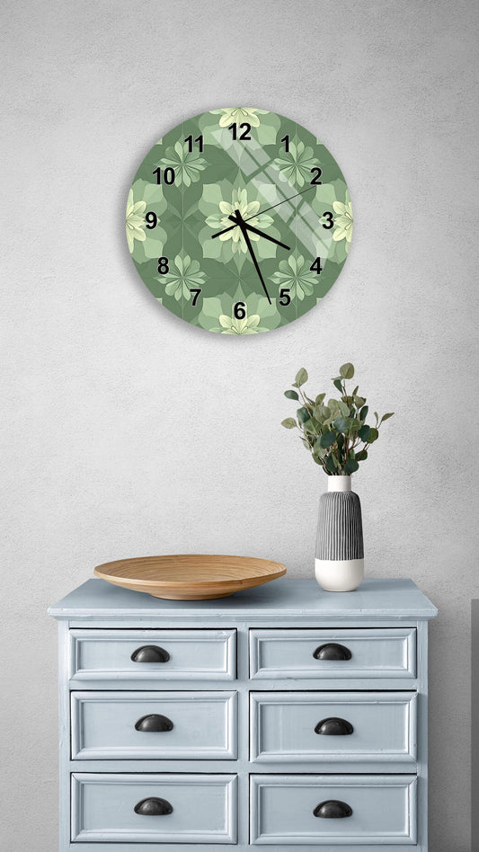 a wall clock with a green floral design, a wooden bowl on a light blue dresser, and a vase with greenery on a gray wall.