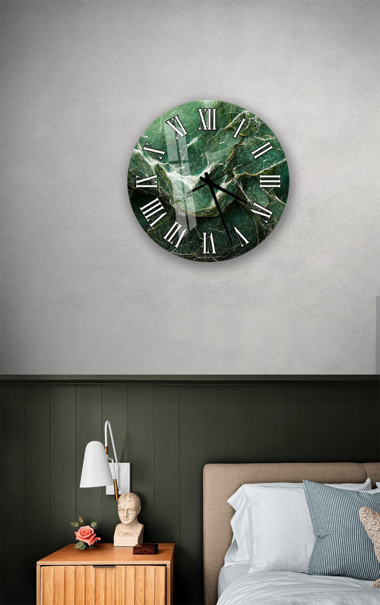 a bedroom setting with a large green marble clock on the wall above a bed. The clock has a unique green marble design and is positioned above the bed. The room also includes a nightstand with a lamp and a small statue.