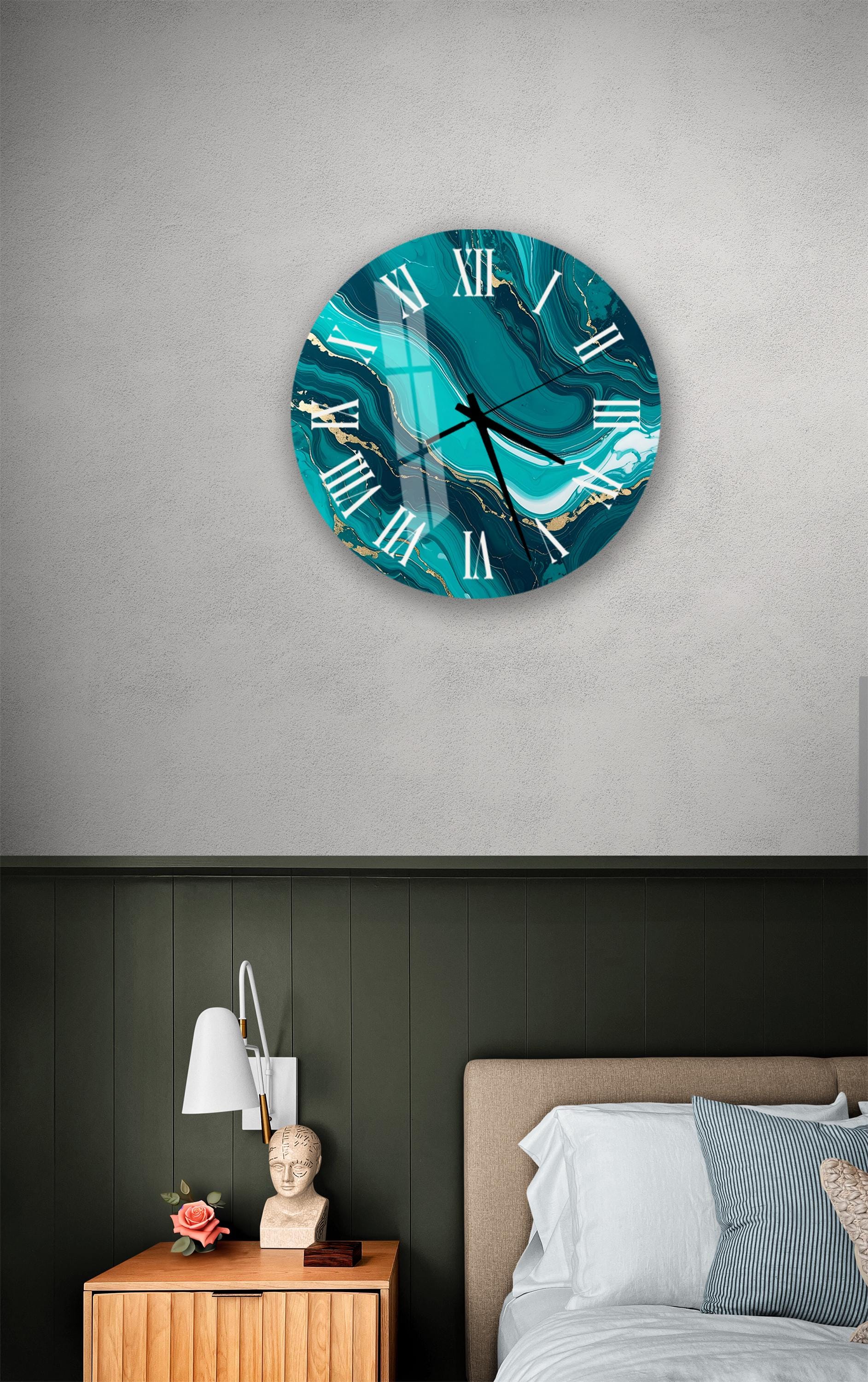 a bedroom setting with a large turquoise wall clock hanging above a bed. The clock has a marble-like design and is mounted on a gray wall. Below the clock, there is a wooden nightstand with a lamp and a small statue.