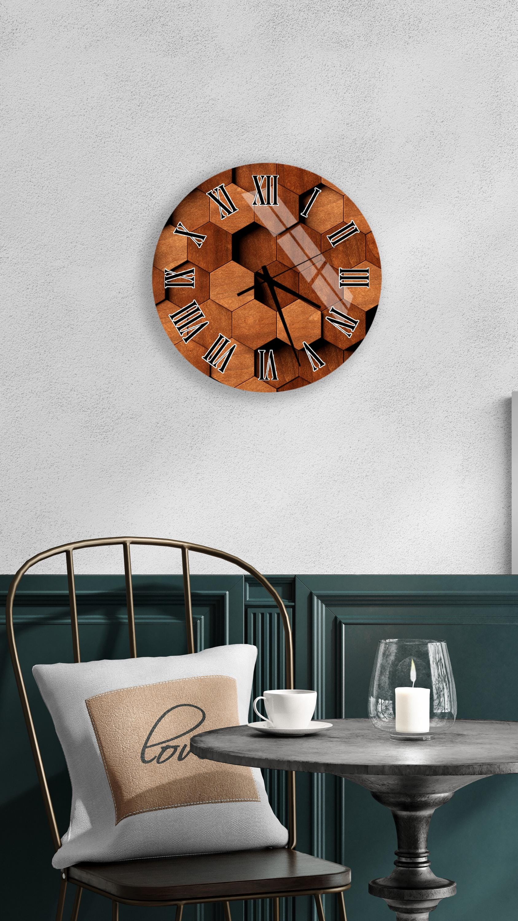 a wall clock with a wooden design, a white table with a candle and a cup, and a chair with a pillow on it.