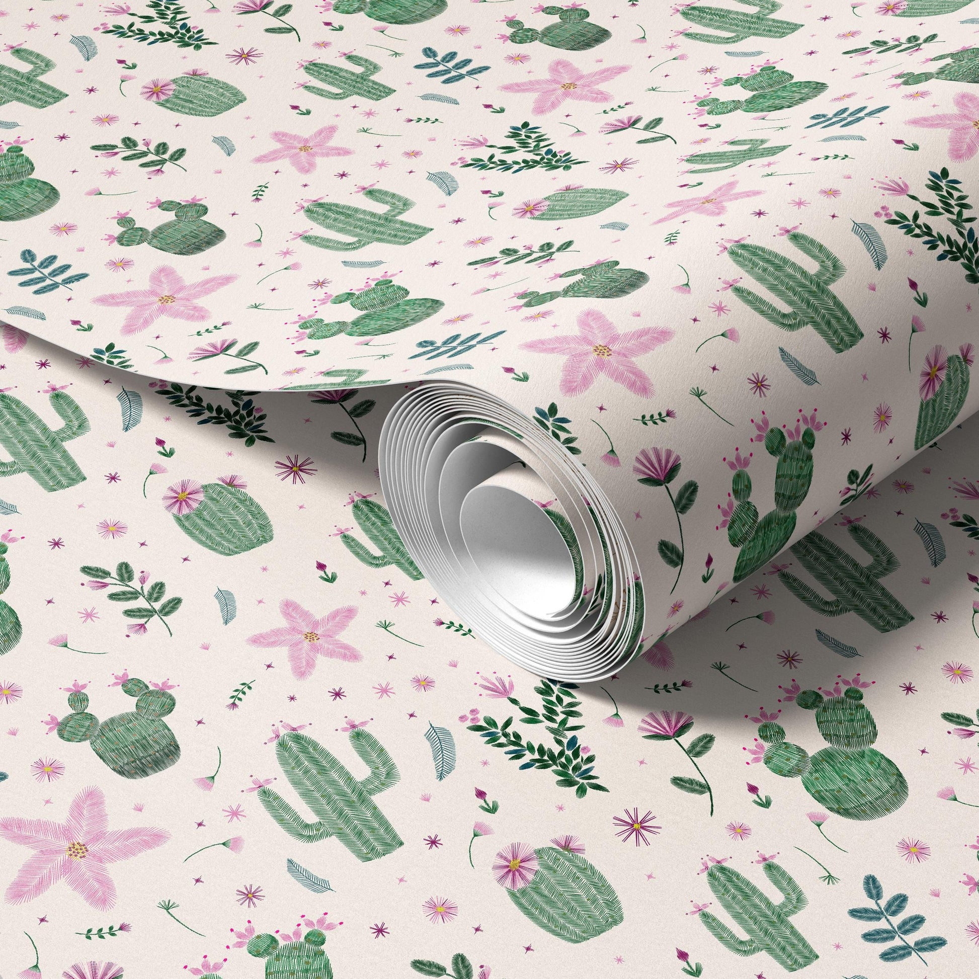 a roll of wallpaper with a repeating pattern of cacti, flowers, and leaves in shades of pink and green.
