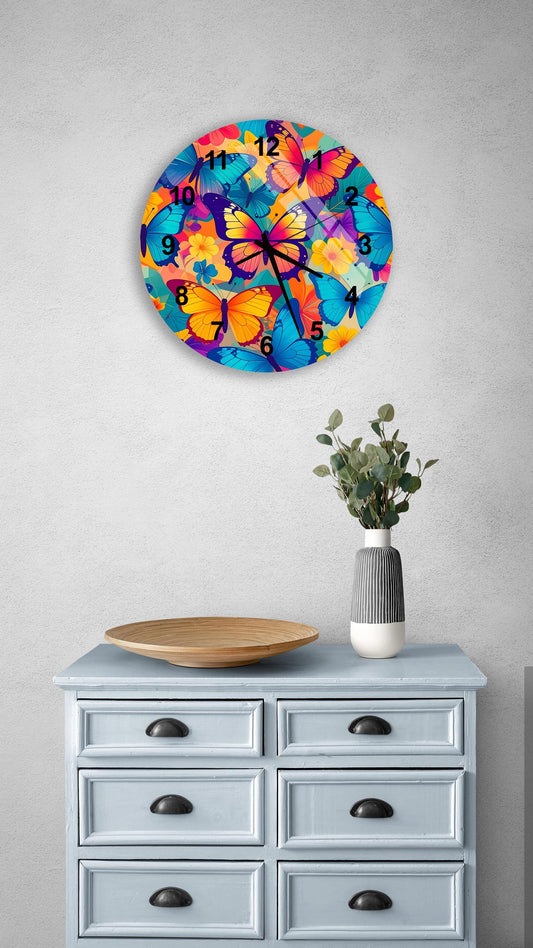 a wall clock with a butterfly design, mounted on a wall above a wooden dresser with drawers. The dresser also has a vase with greenery and a wooden tray on it.
