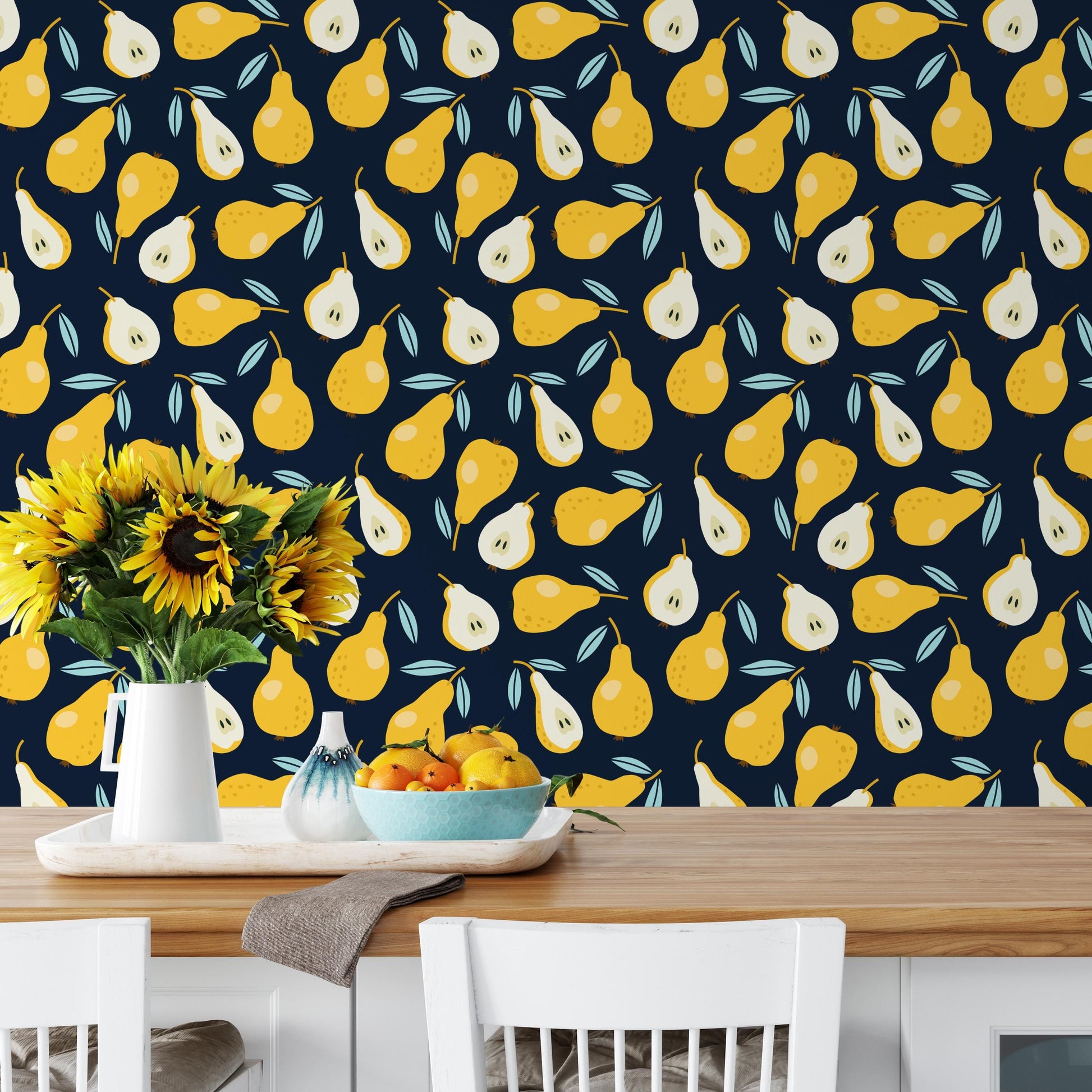 a dining table with a vase of sunflowers, a bowl of fruit, and a white chair. The table is set against a wall with a repeating pattern of yellow and green pears.