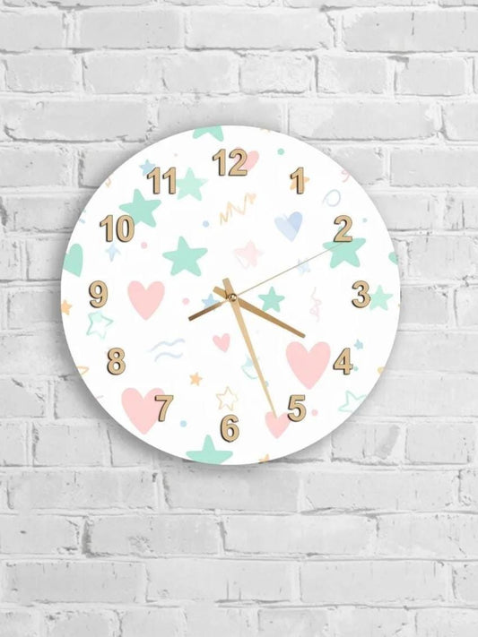 A round wall clock with a white background and colorful numbers and shapes, such as stars, hearts, and waves, is mounted on a white brick wall.