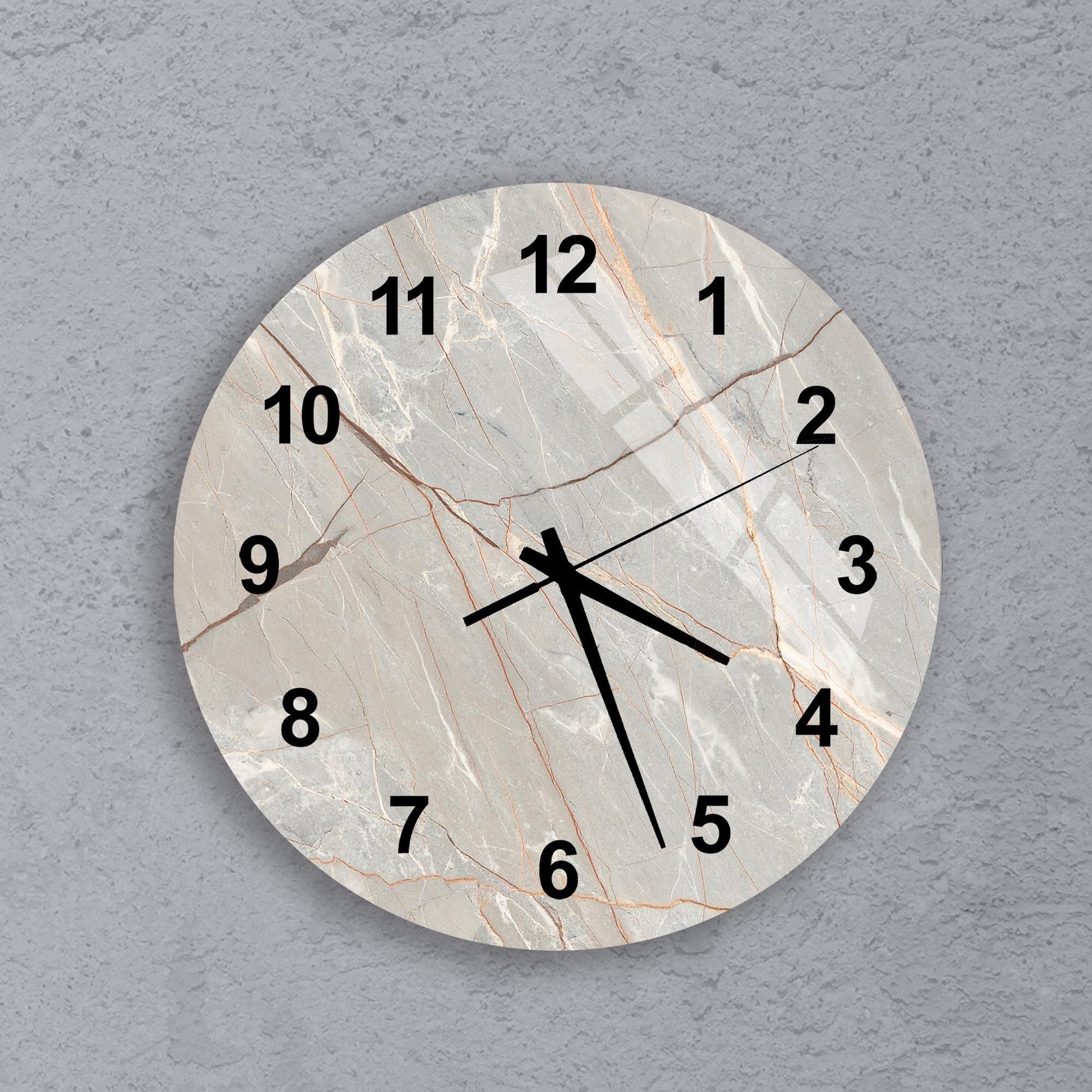 A round wall clock with a marble-like texture and black numbers on a gray background.