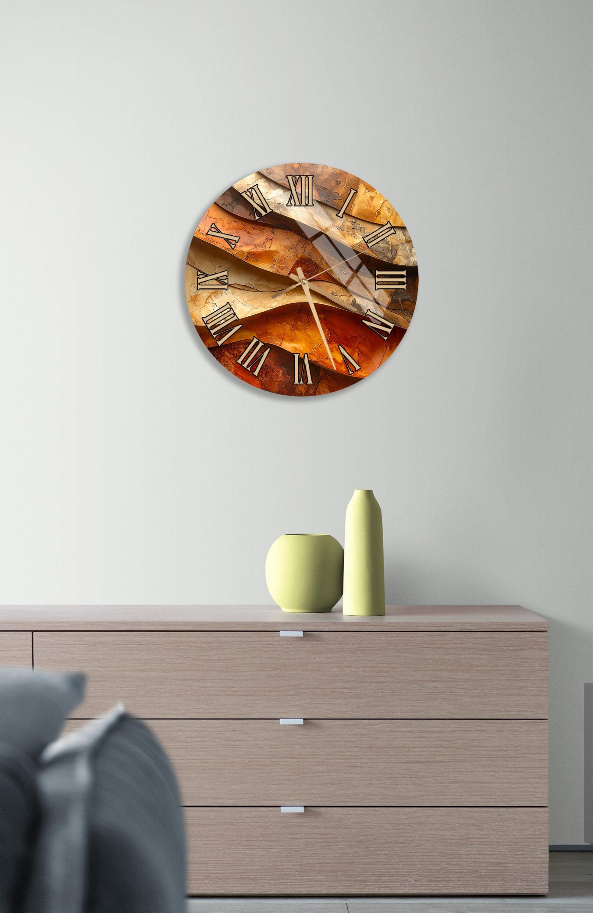 a modern clock with a unique design, mounted on a wall above a wooden dresser.