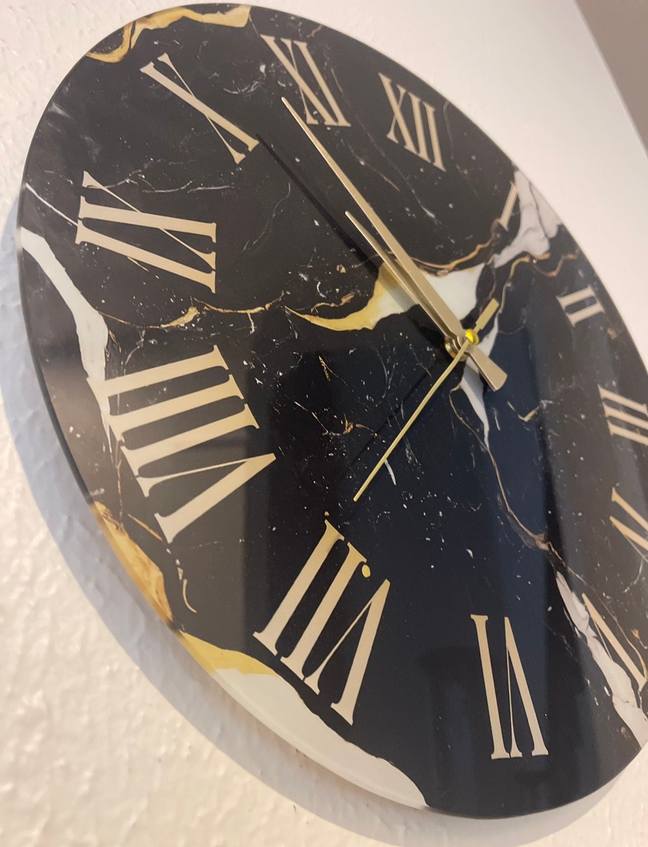 a clock with roman numerals on a white wall